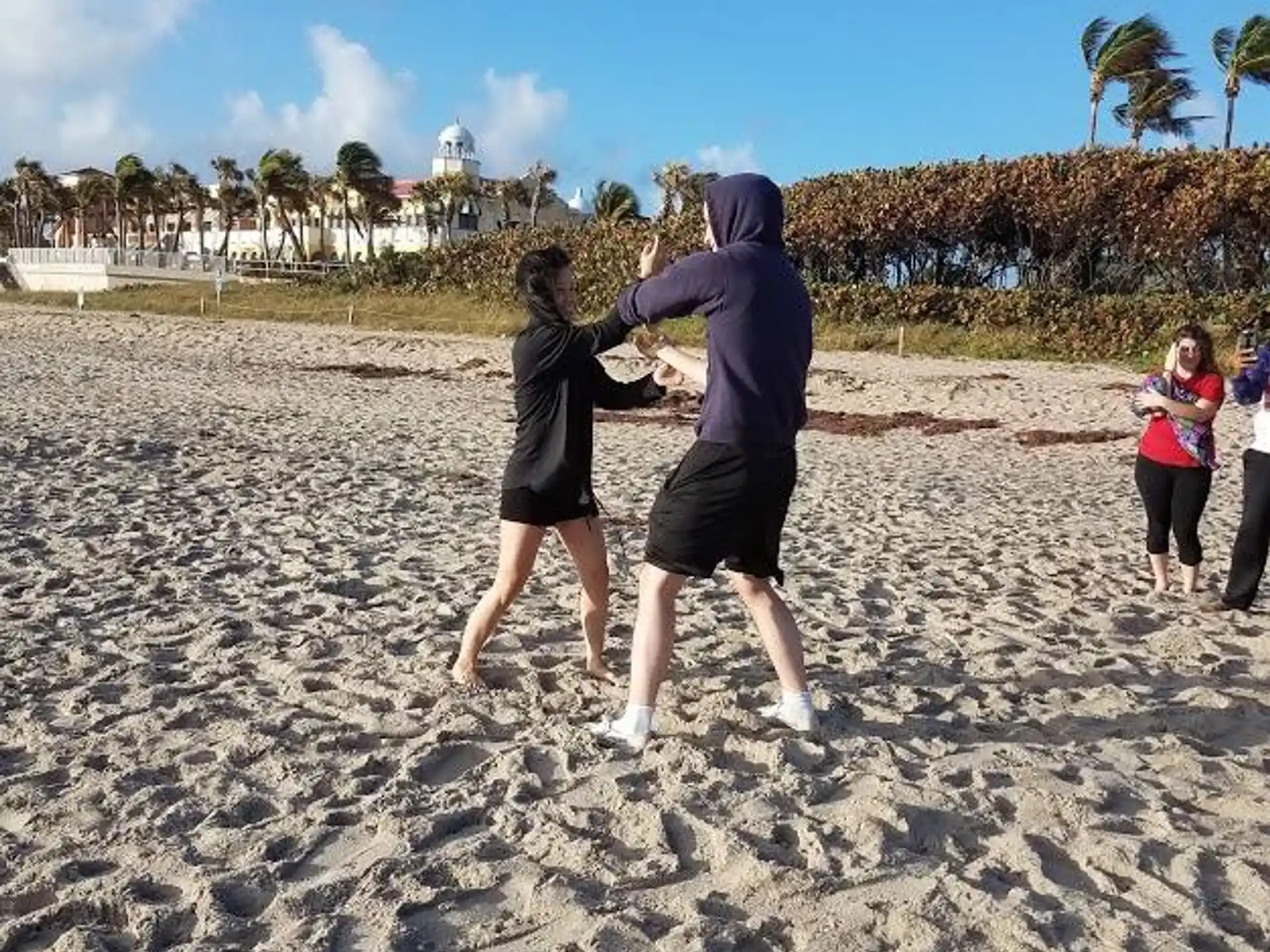 a man and woman holding each other on a beach