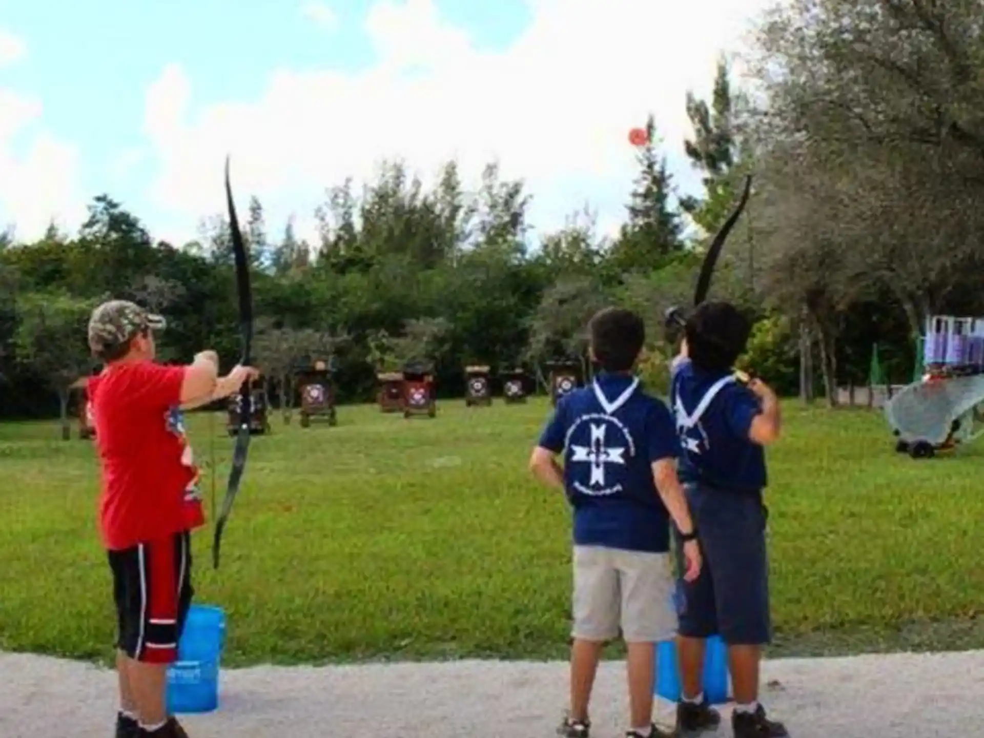a group of boys playing with a bow and arrow