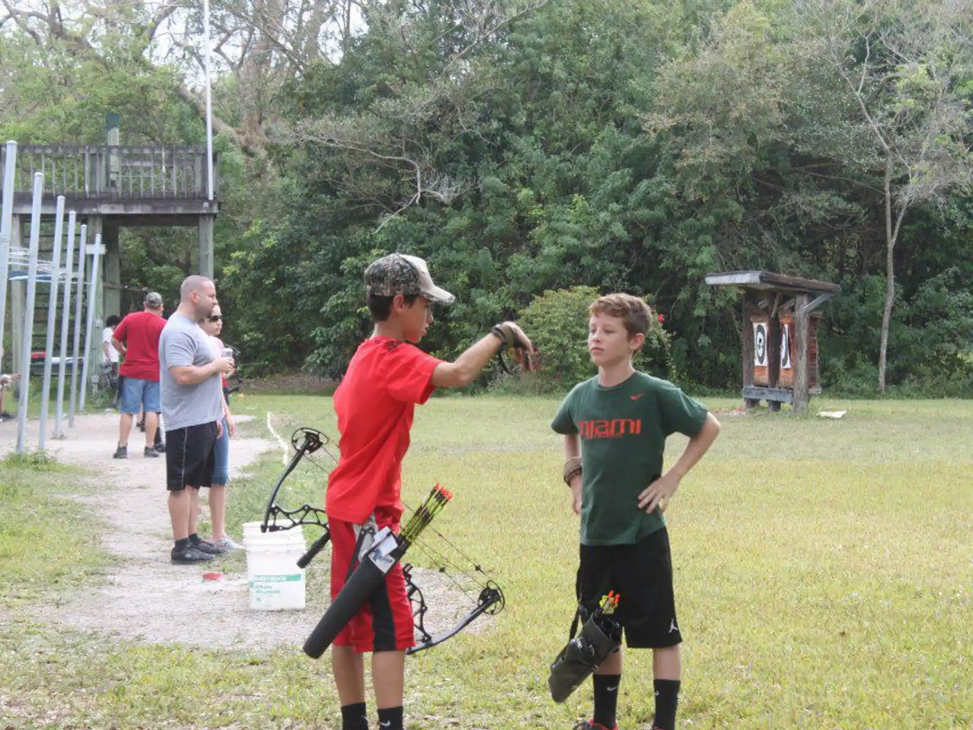 a man and a boy holding a bow and arrow