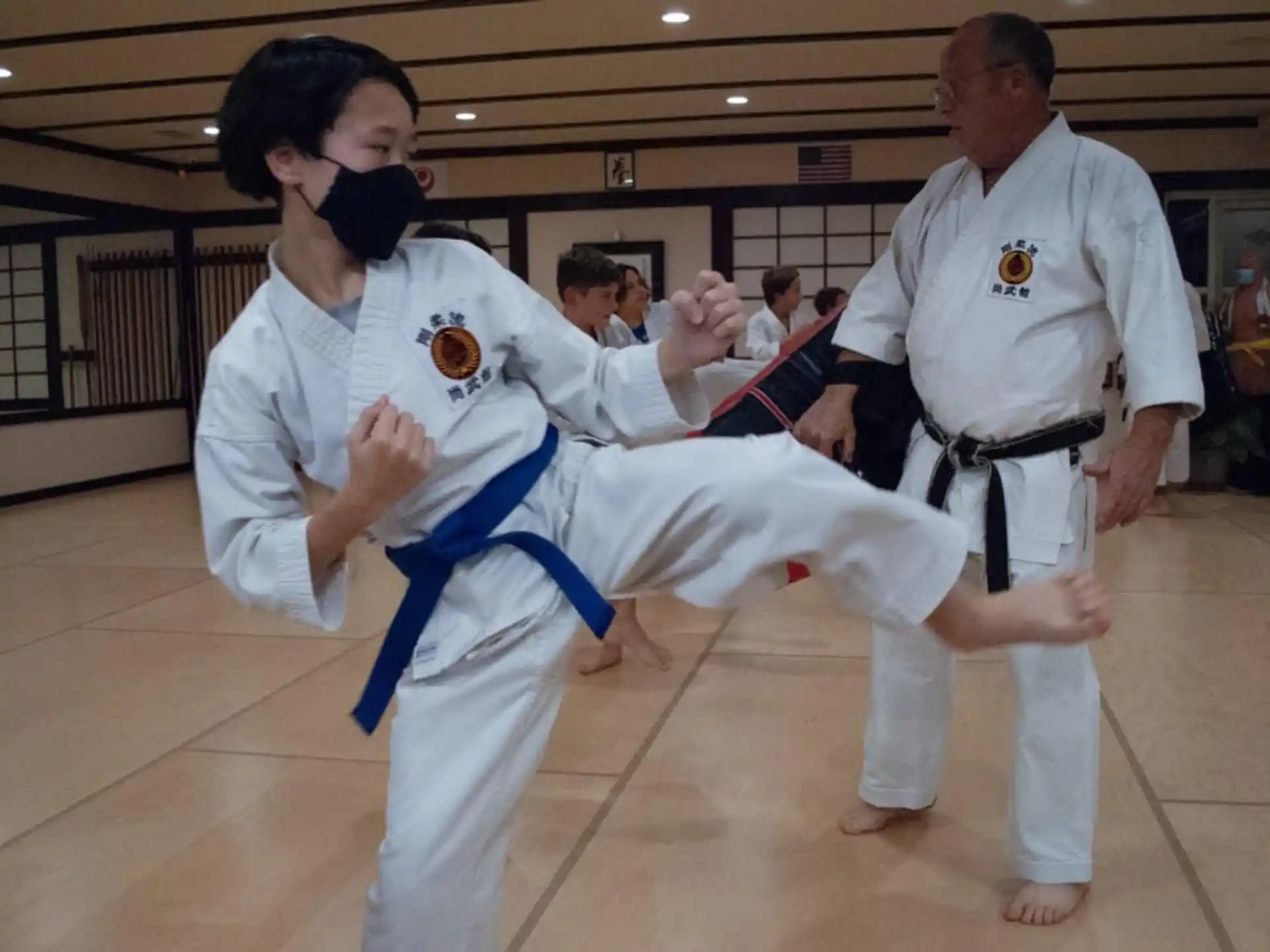 a man in a karate uniform kicking another man in the face