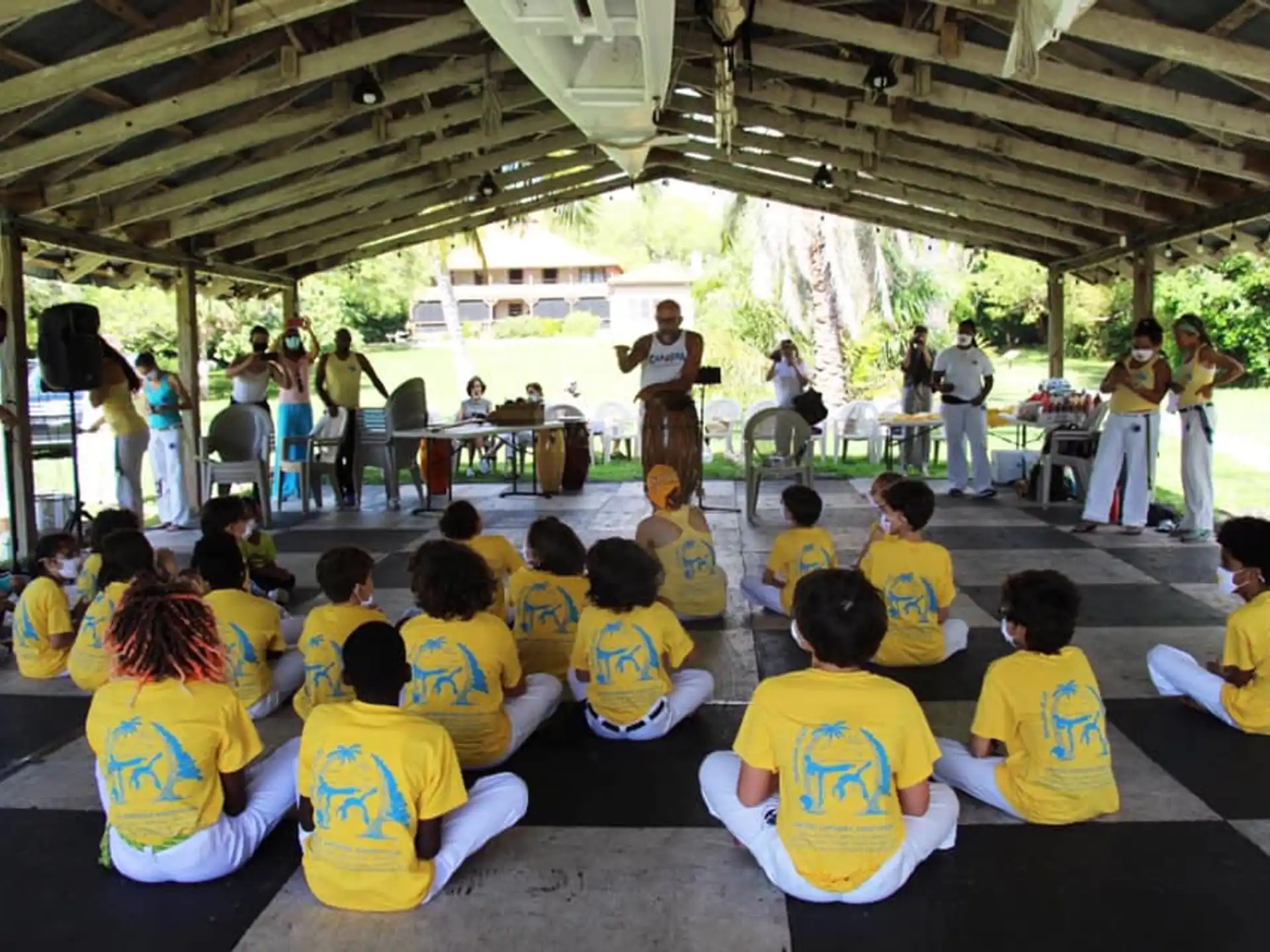 a group of people sitting on the floor watching a person play a guitar
