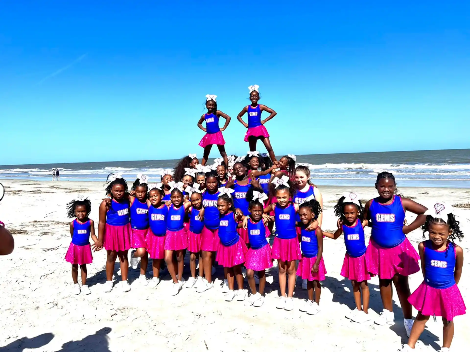 a group of girls posing on a beach