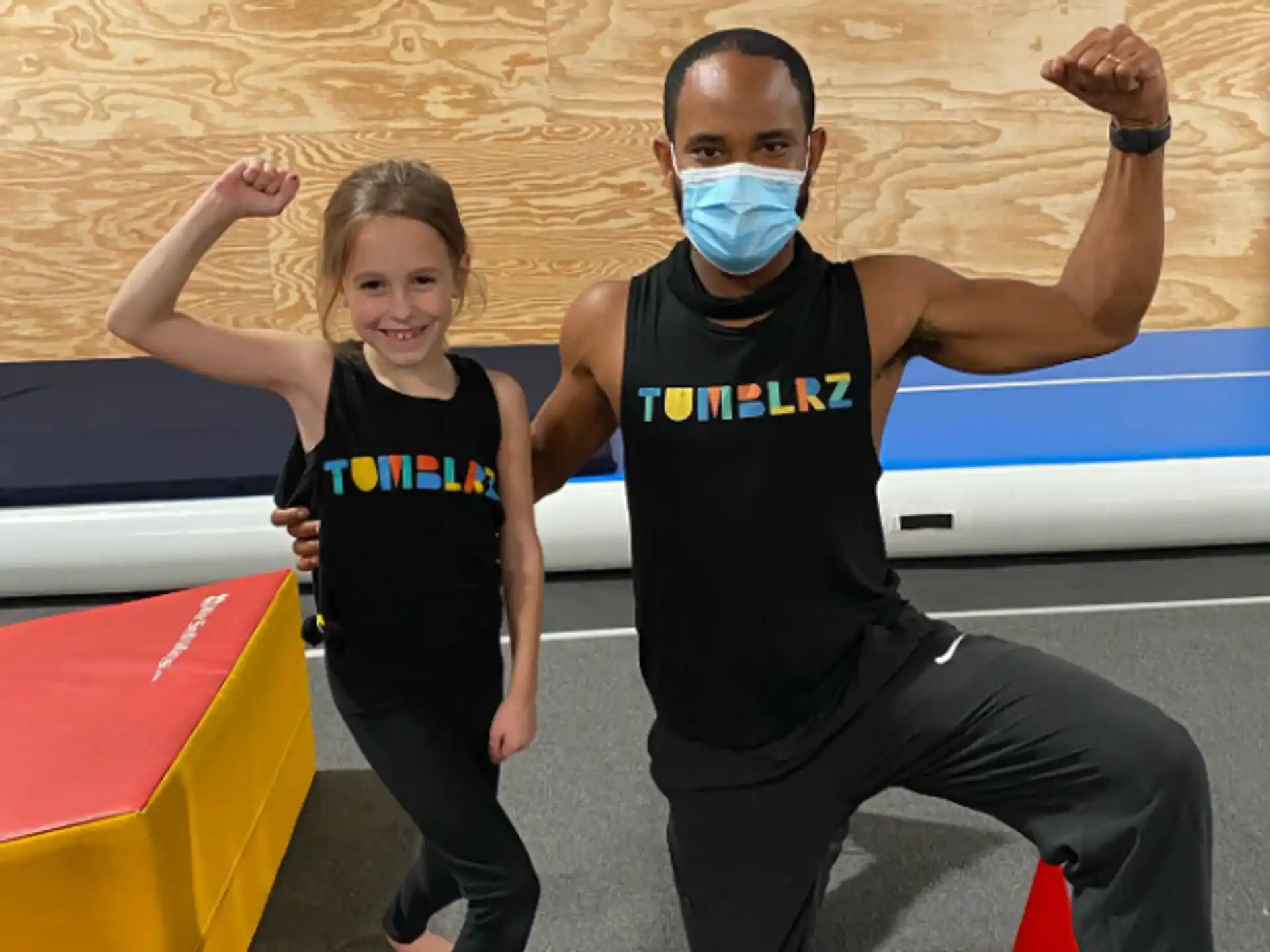 a man and a woman wearing face masks and posing for the camera