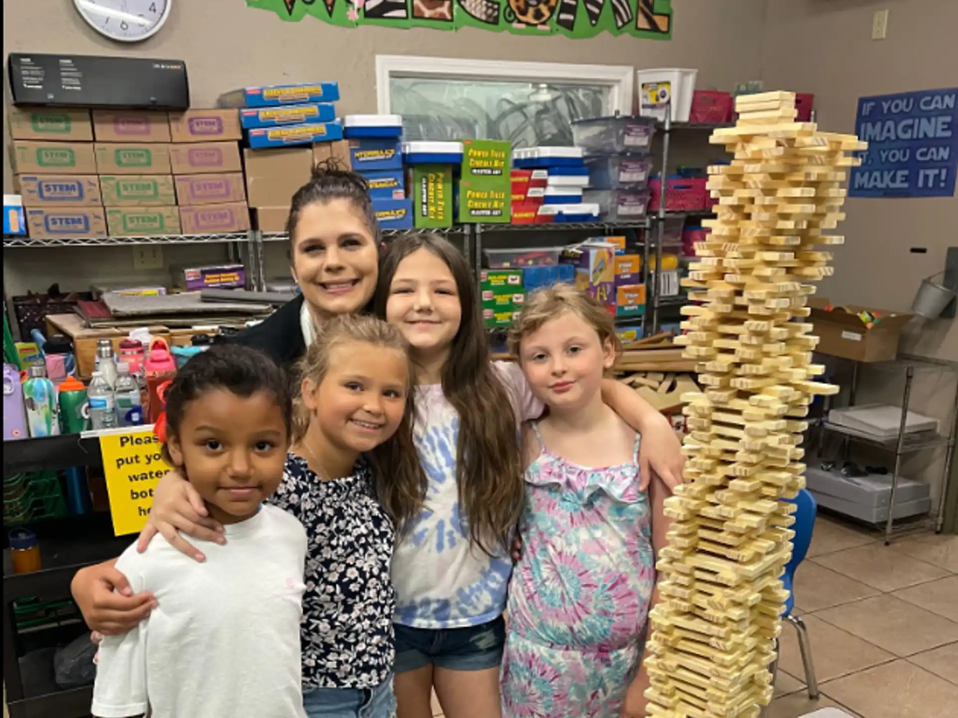 a group of people posing for a photo in front of a display of food