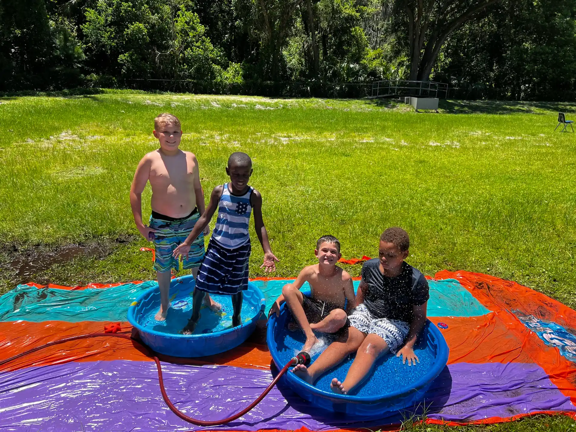 a group of boys on a small pool in a grassy field