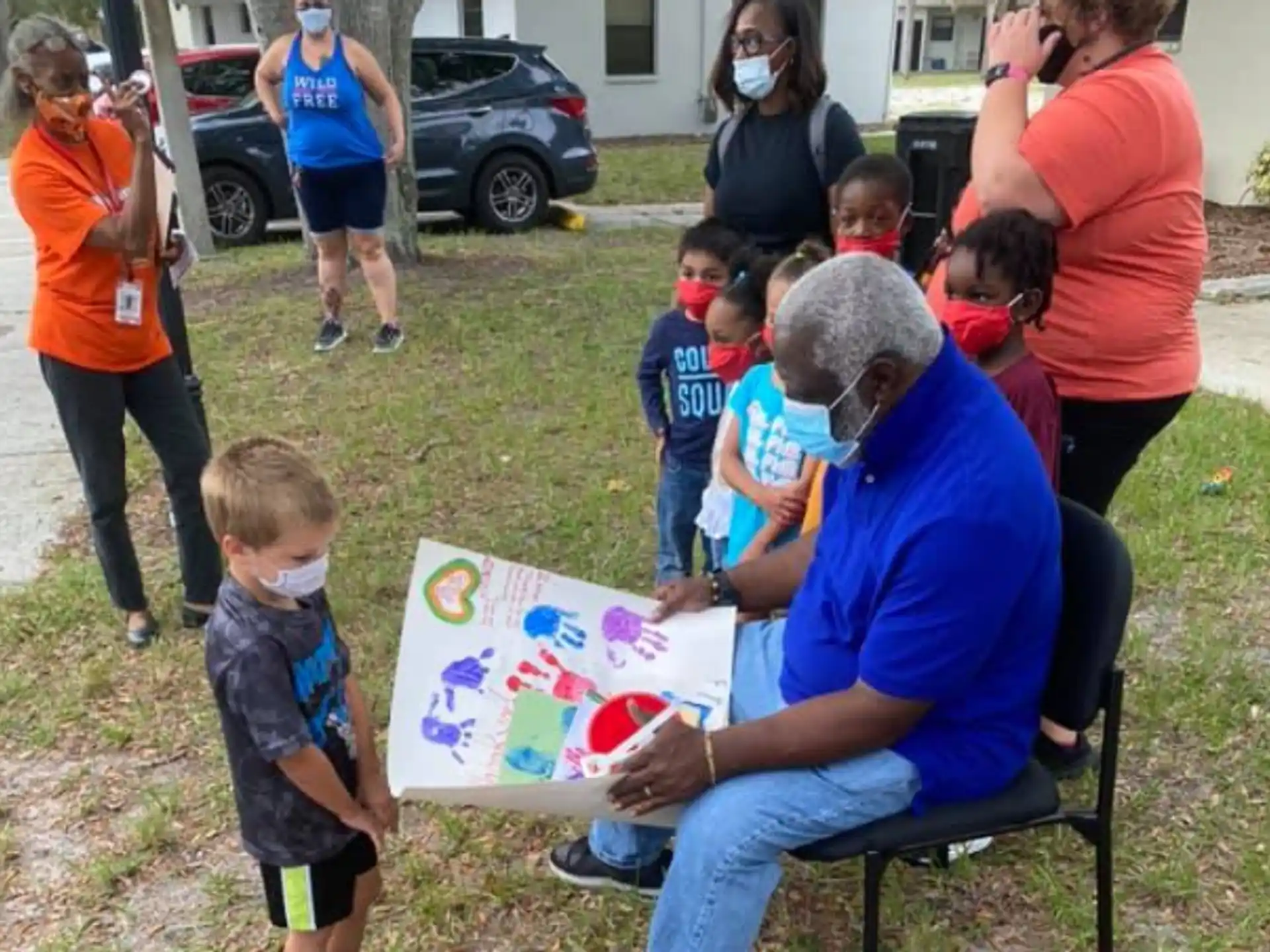 a person reading a book to a group of children