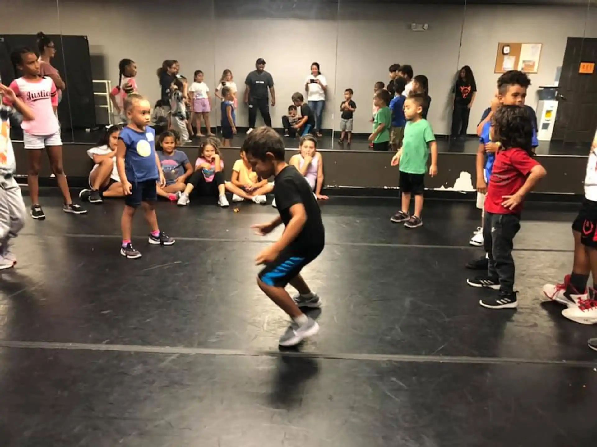 a group of kids playing rollerblading in a gym