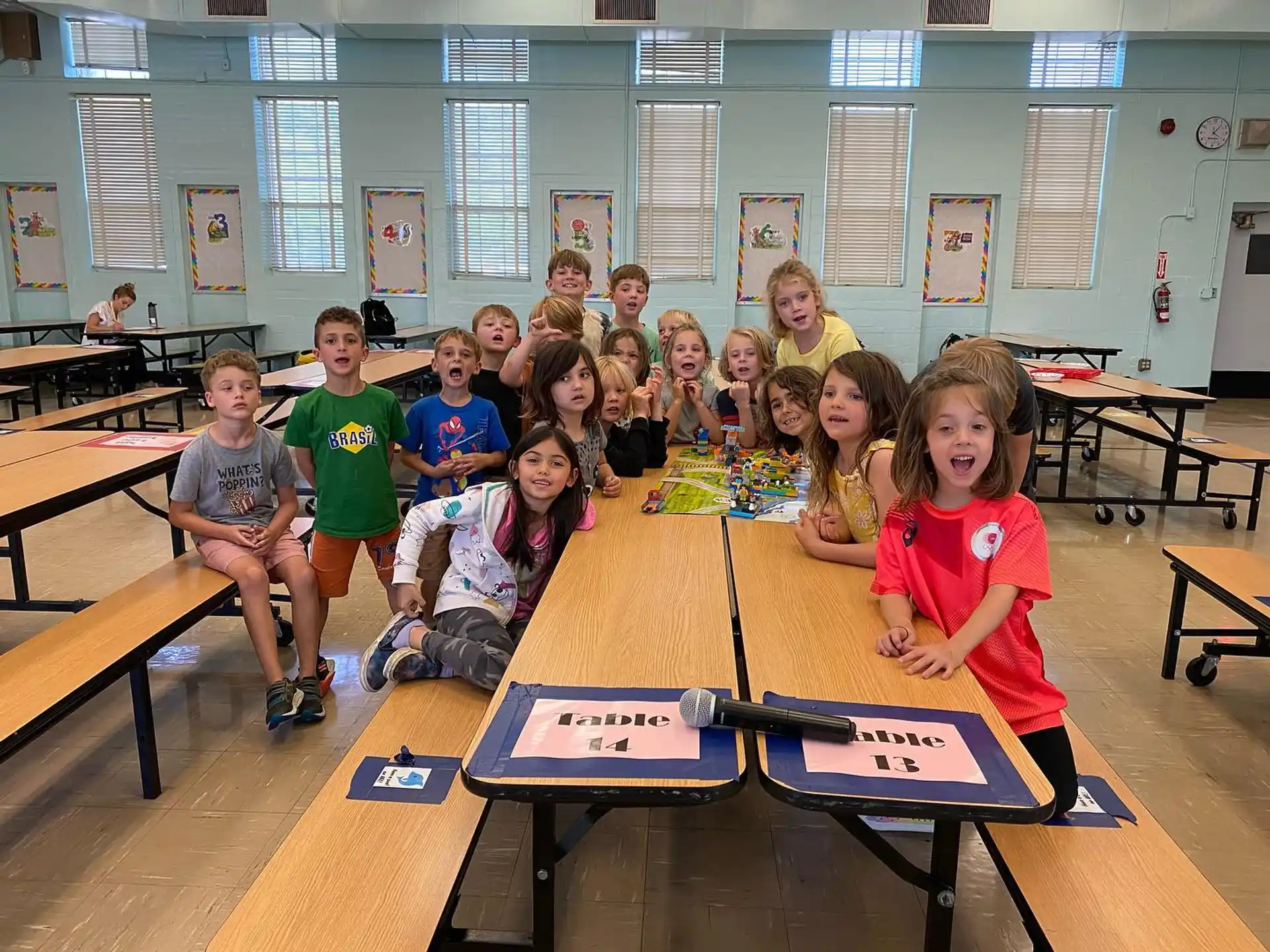 a group of children sitting at a table in a classroom