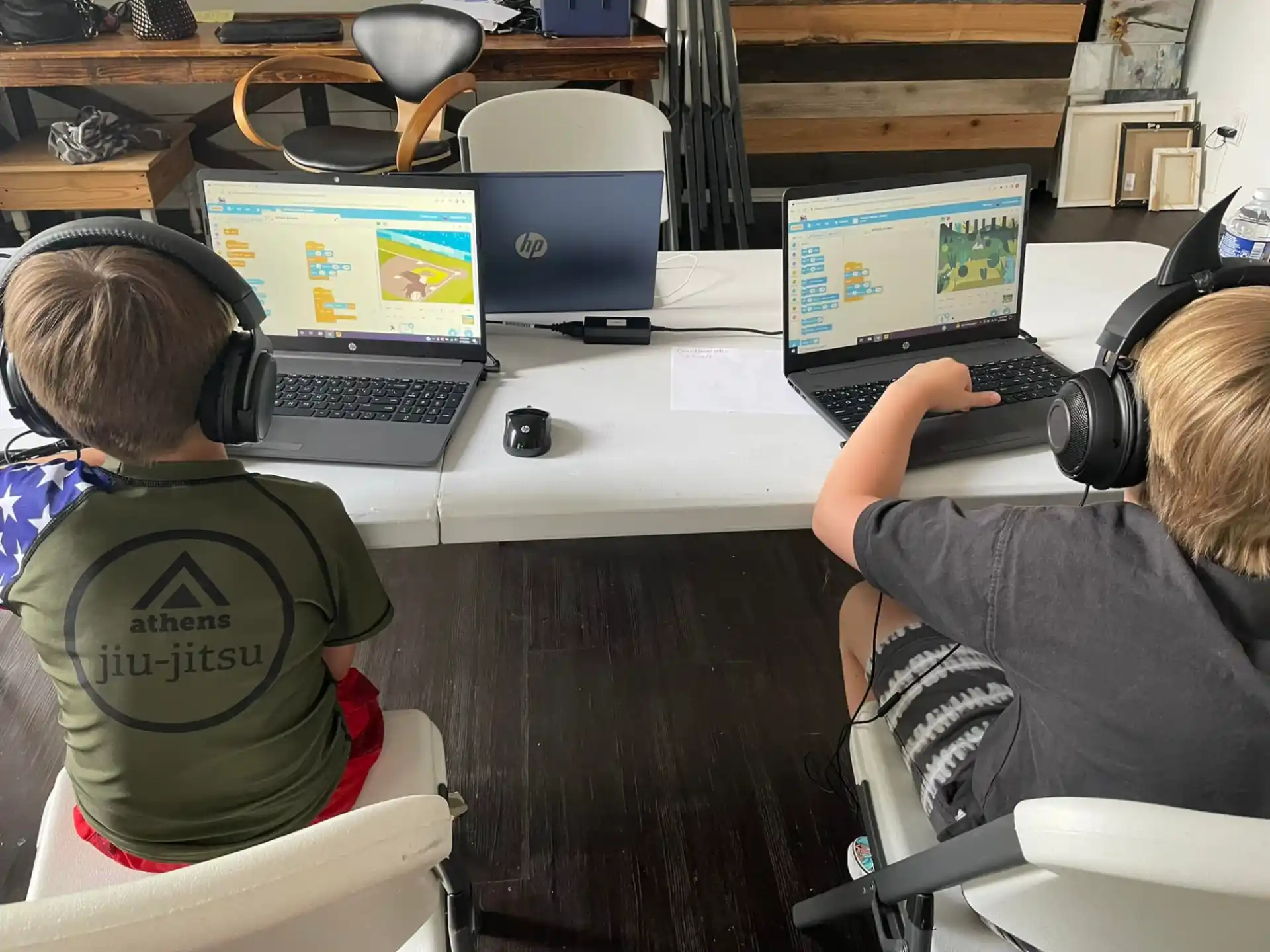 a couple of people sitting at a table with laptops