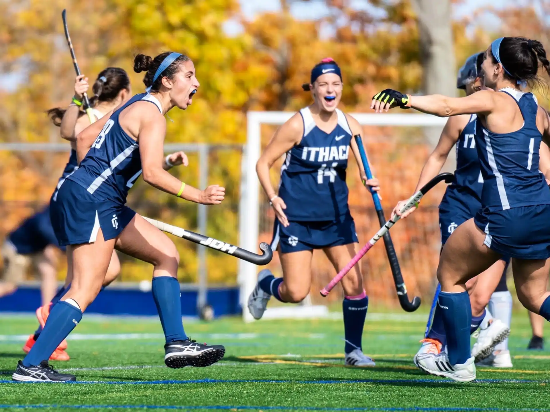 a group of women playing field hockey