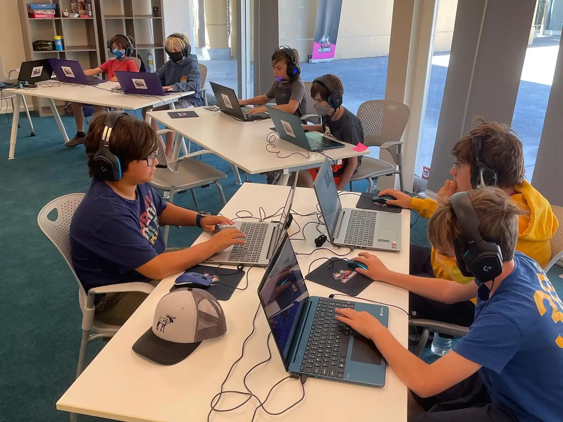 a group of people sitting at tables using laptops