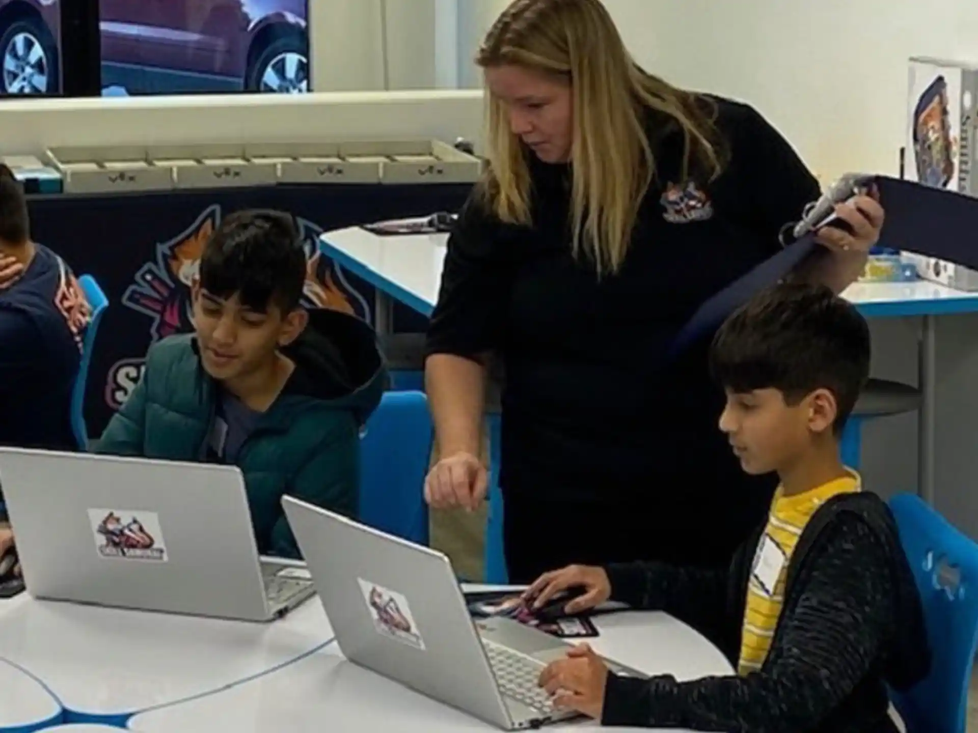 a person showing a boy something on the laptop