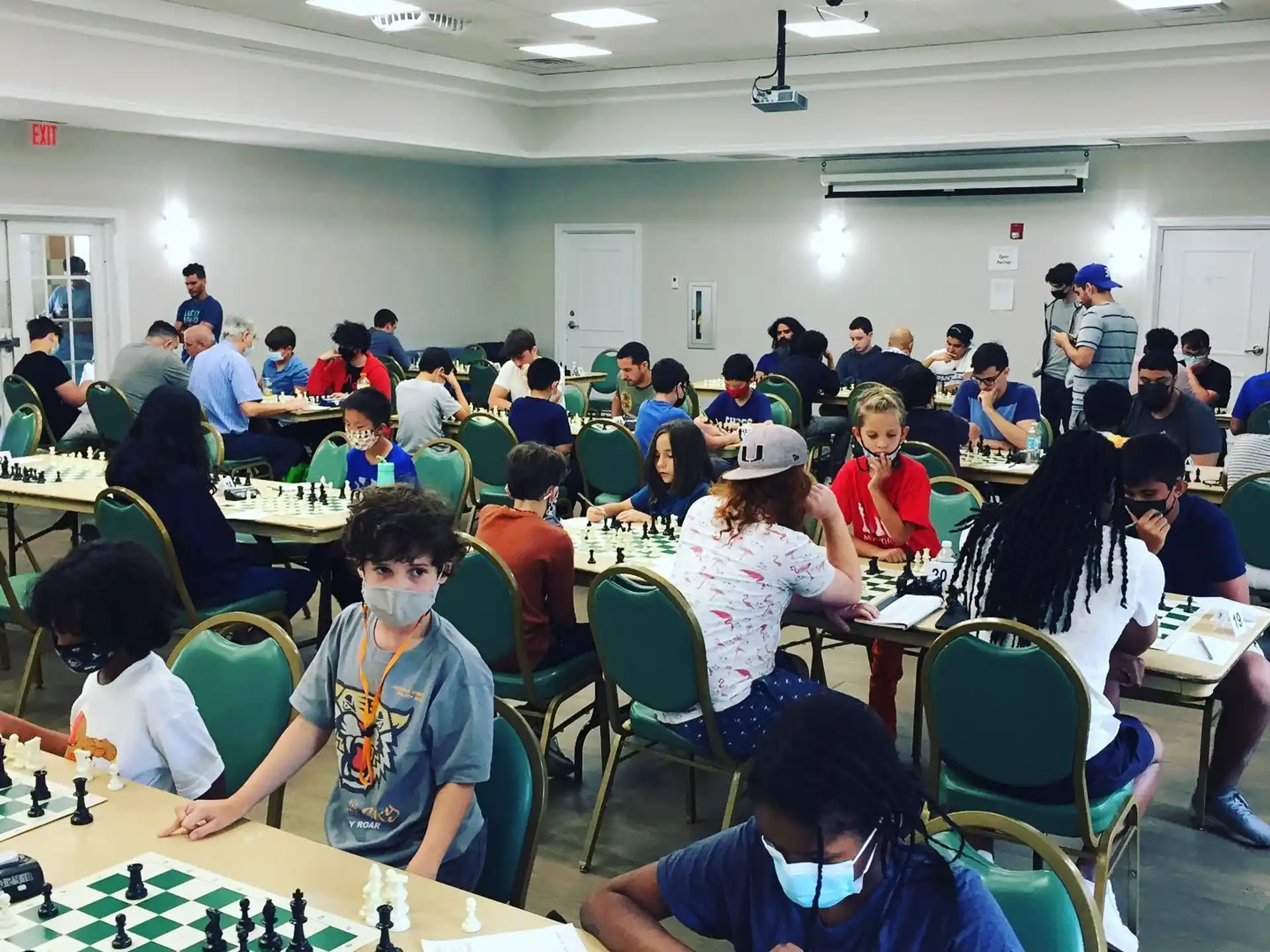 a group of people sitting at a table playing chess