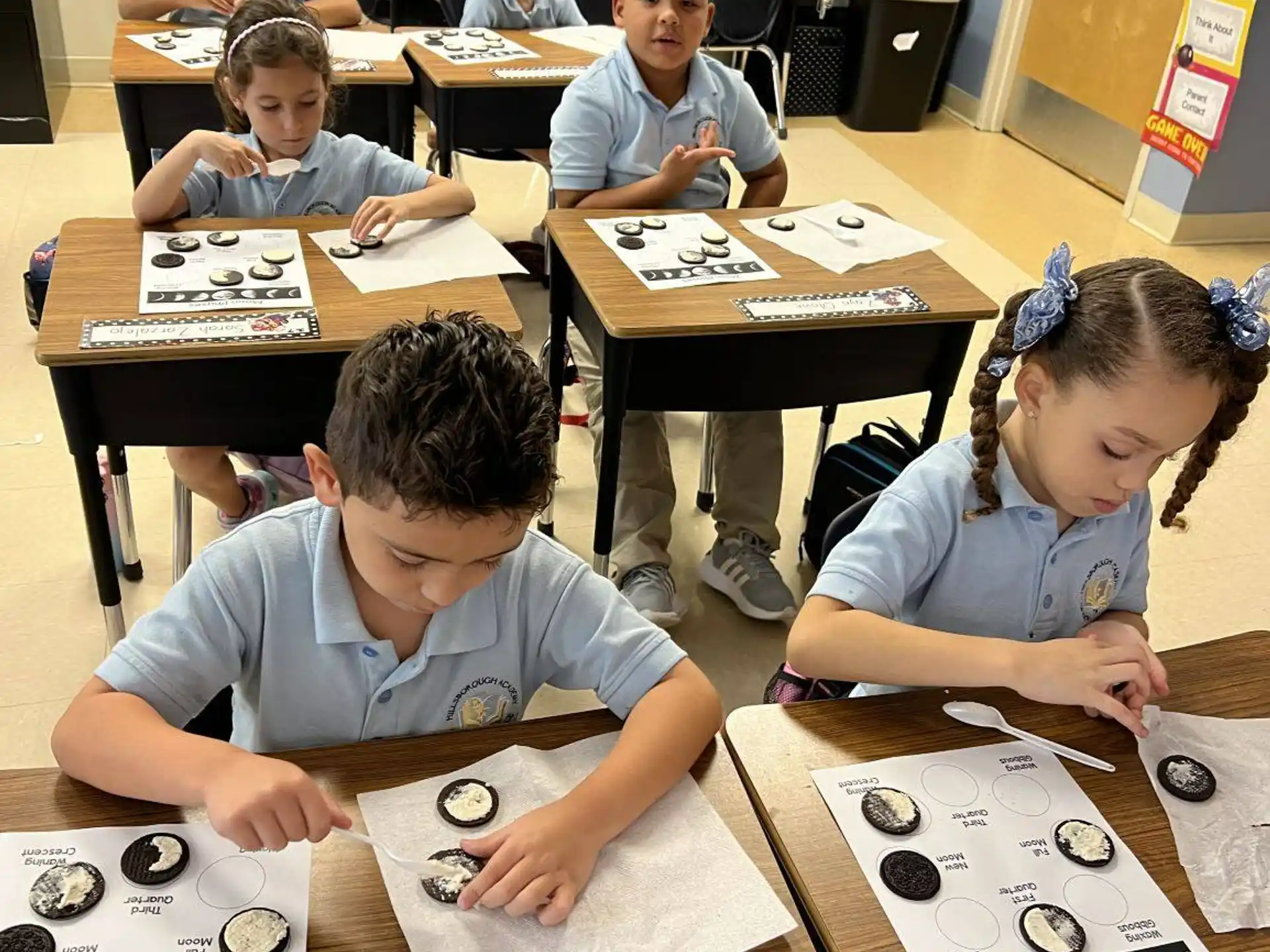 a group of children sitting at desks playing a board game
