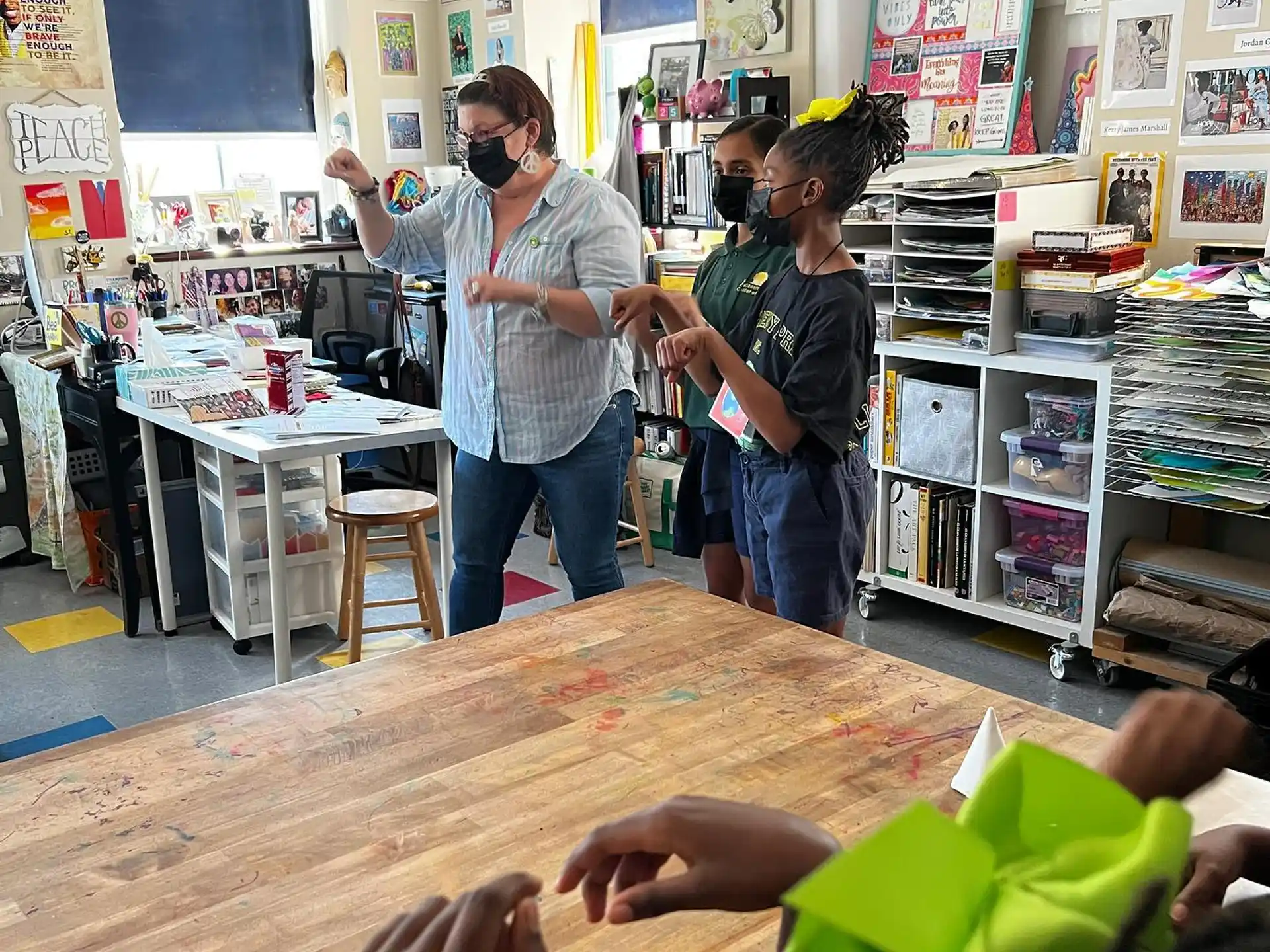 a person standing in a room with a person sitting on the floor