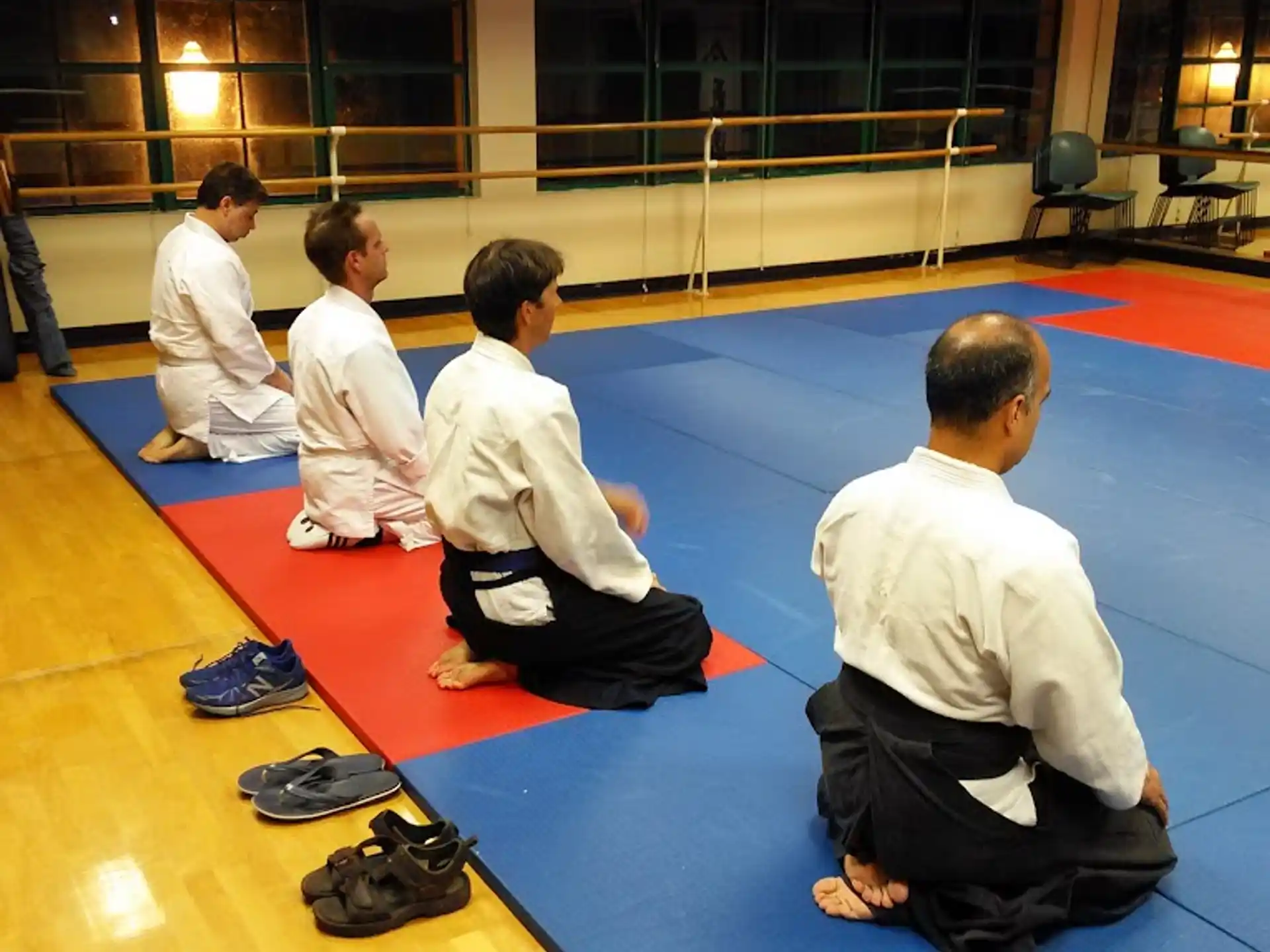 a group of people in white karate uniforms sitting on a mat