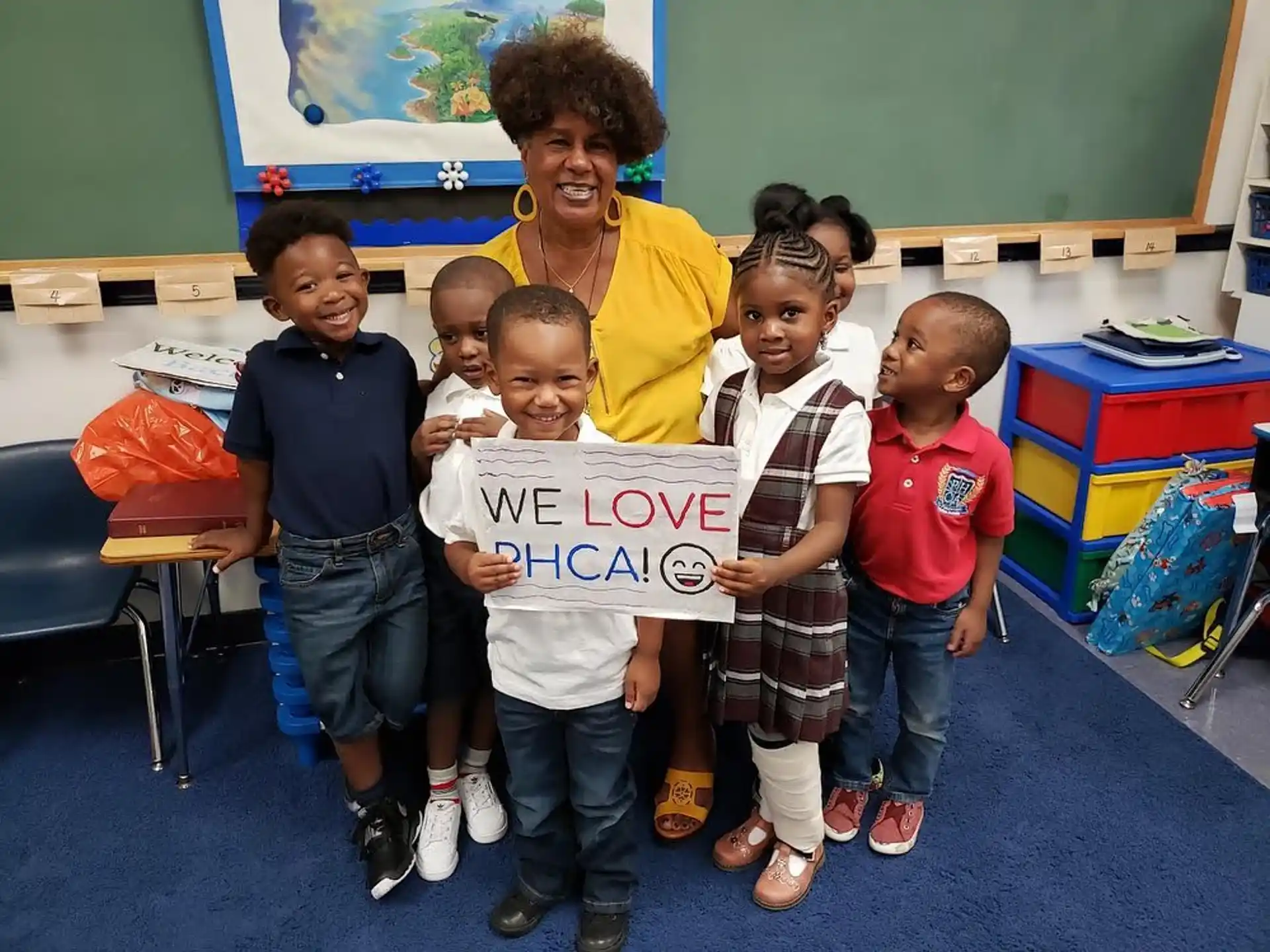 a person and several children holding a sign