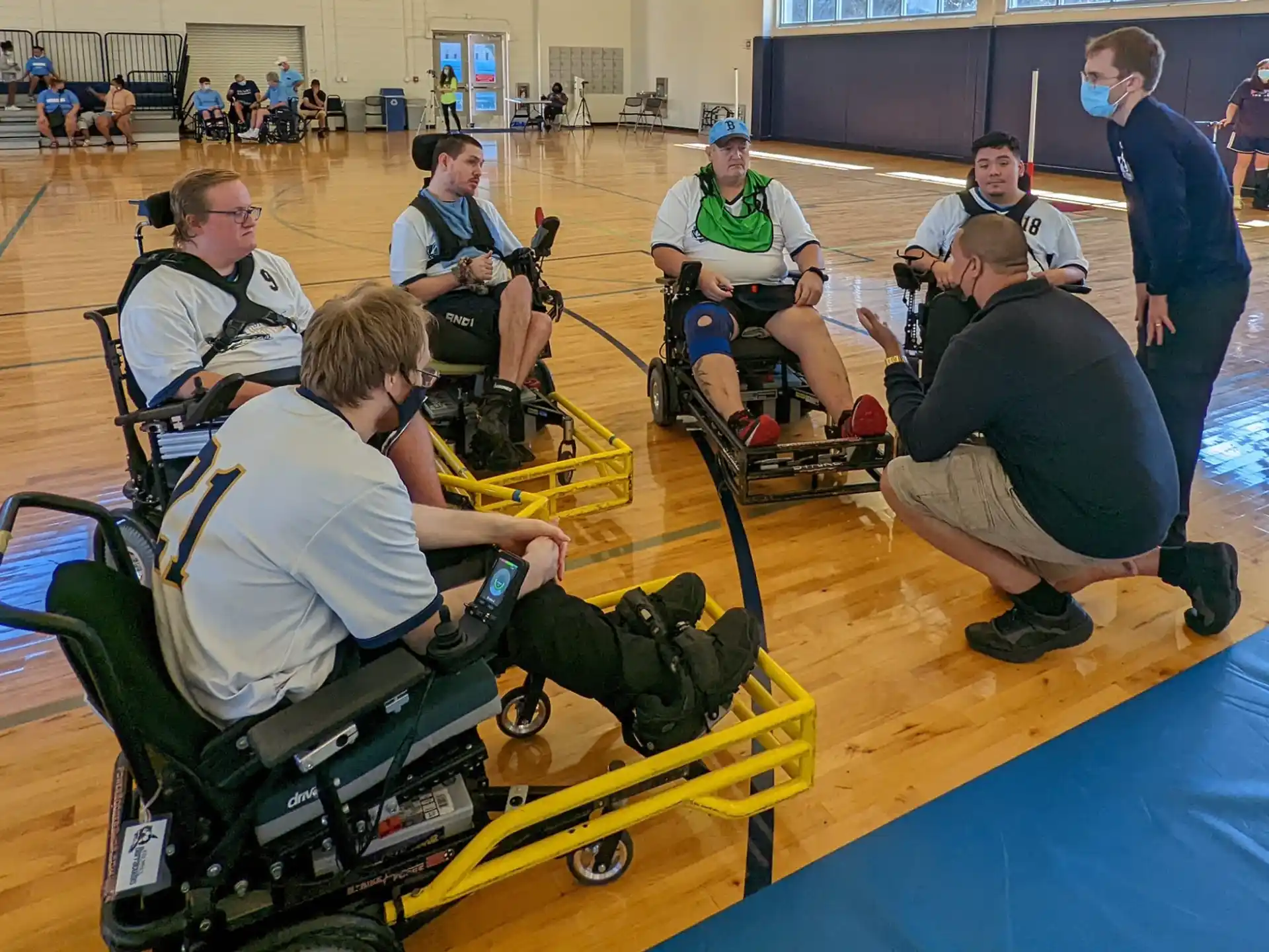 a group of people sitting on a yellow and blue exercise machine