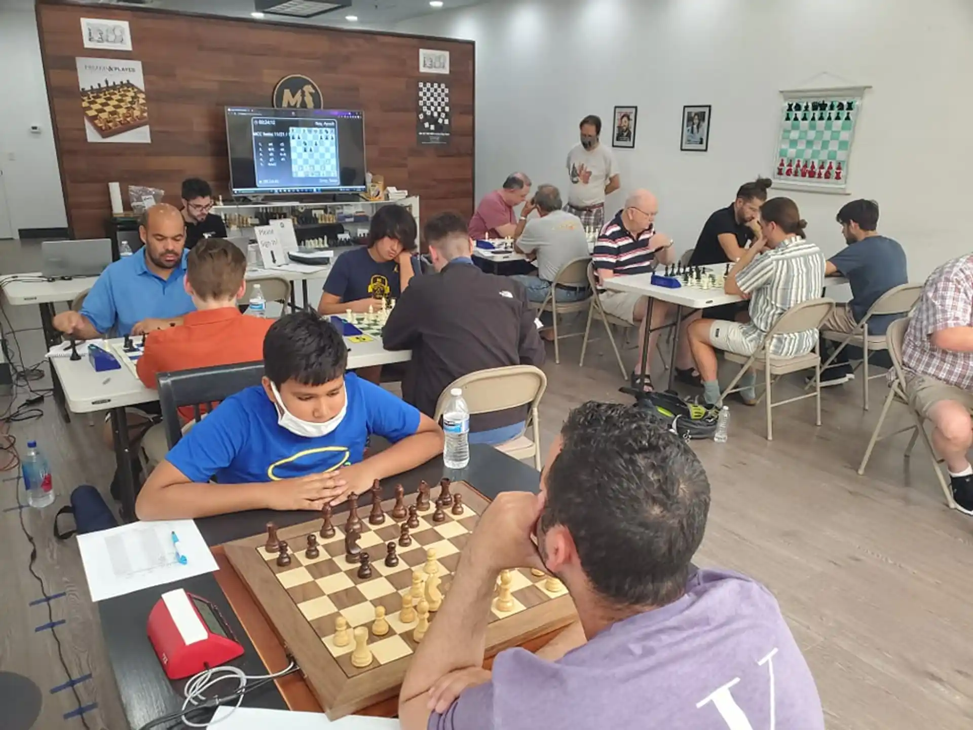 a group of people sitting at tables playing chess