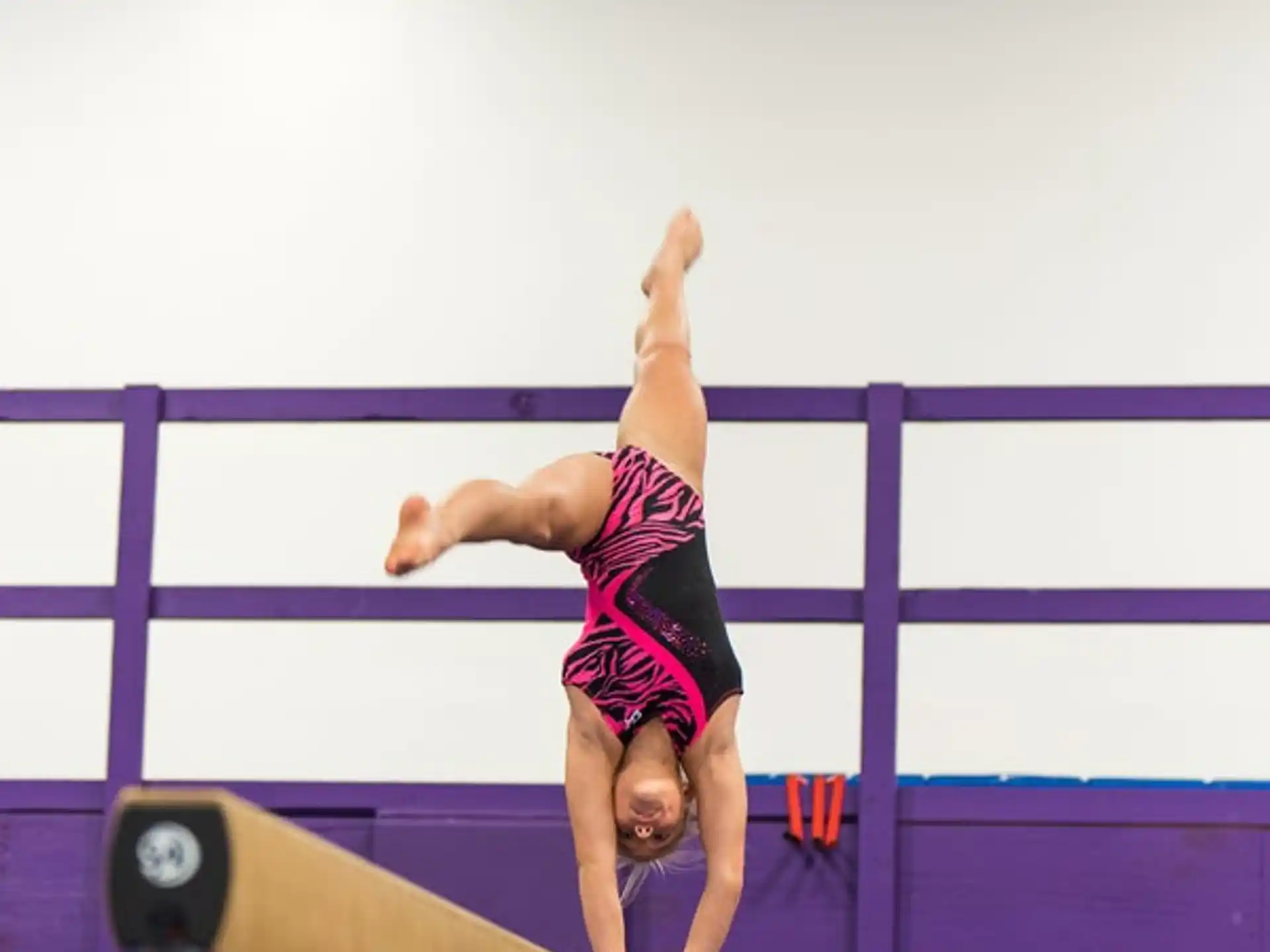 a woman doing a handstand on a bar