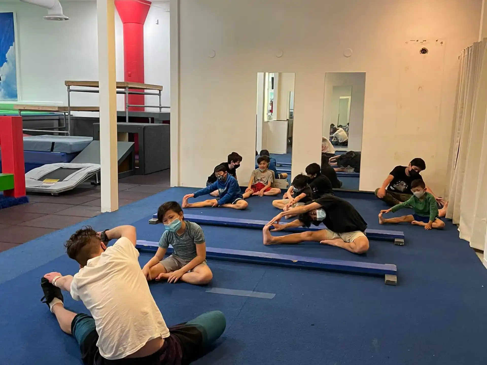 a group of people sitting on mats in a room