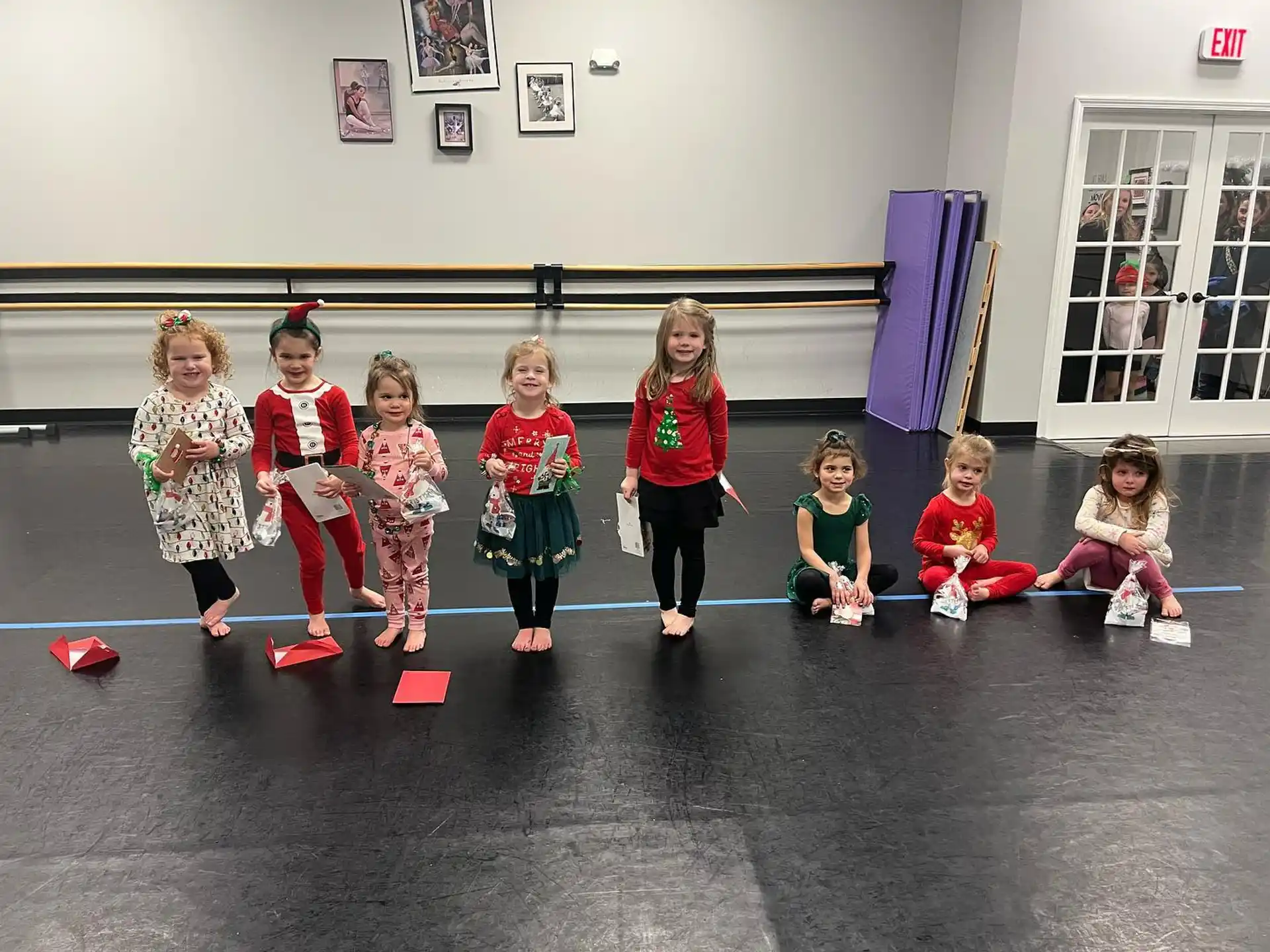 a group of children in red and white uniforms on a black floor