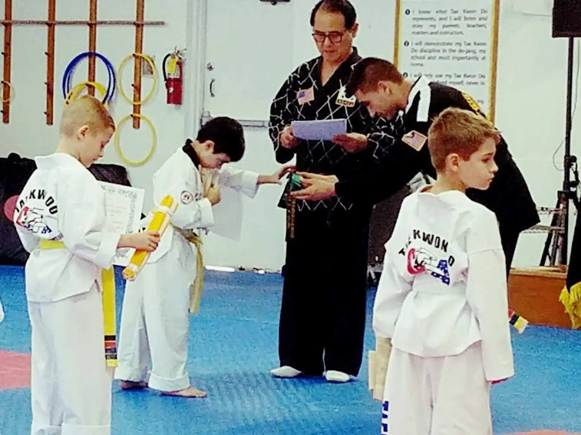 a person standing in front of a group of kids in karate uniforms