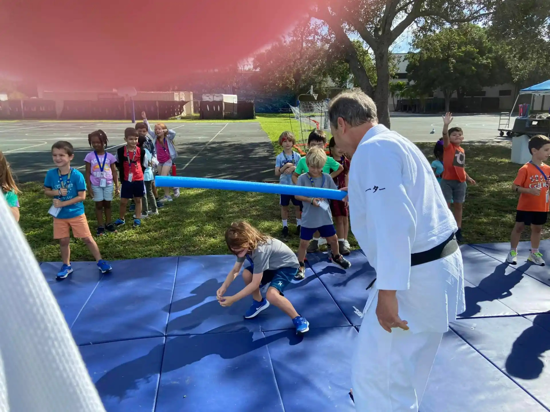 a person and a group of children playing on a trampoline