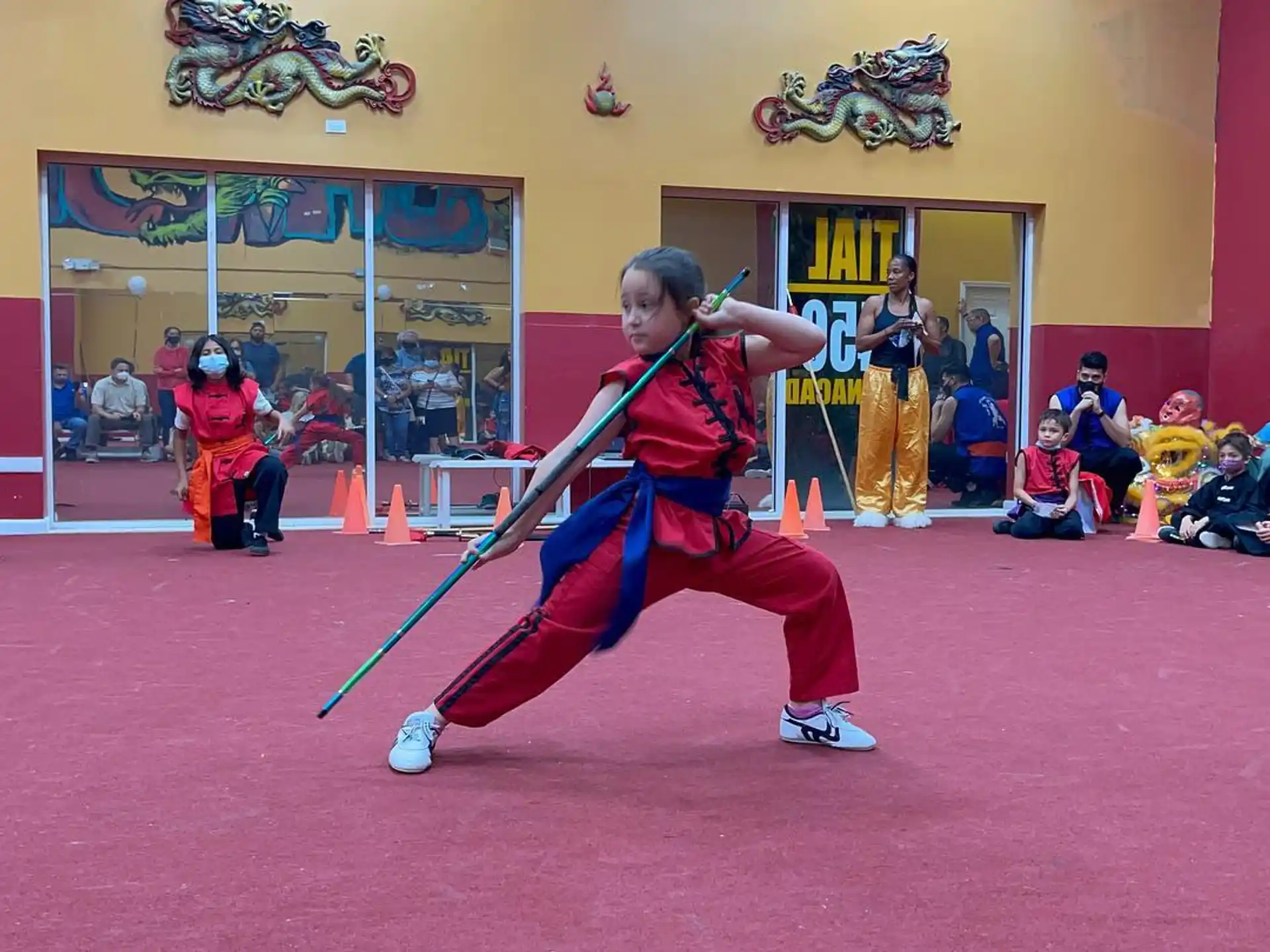 a person in a red uniform holding a sword in front of a crowd