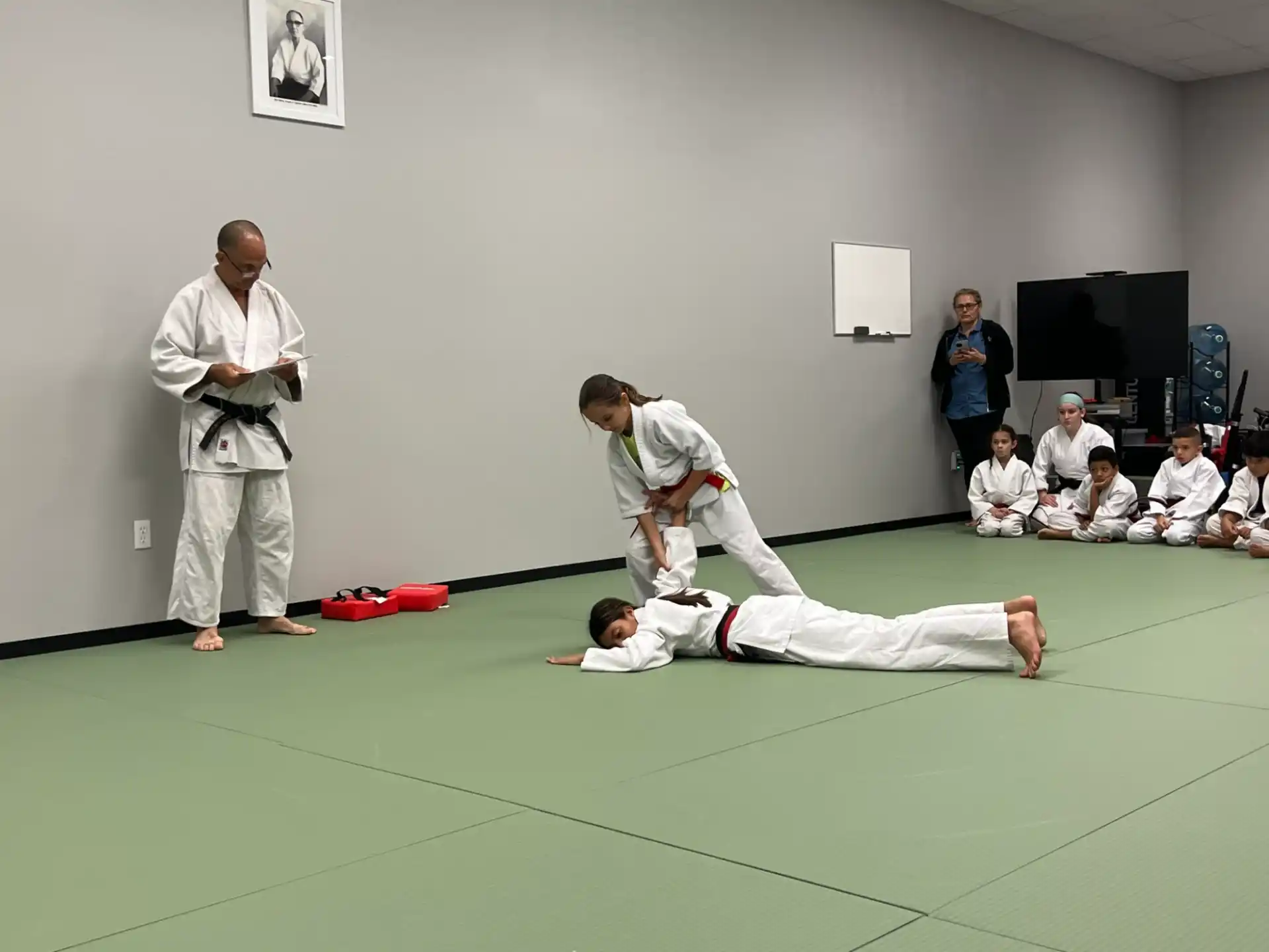 a person kicking another man in the face with a crowd watching
