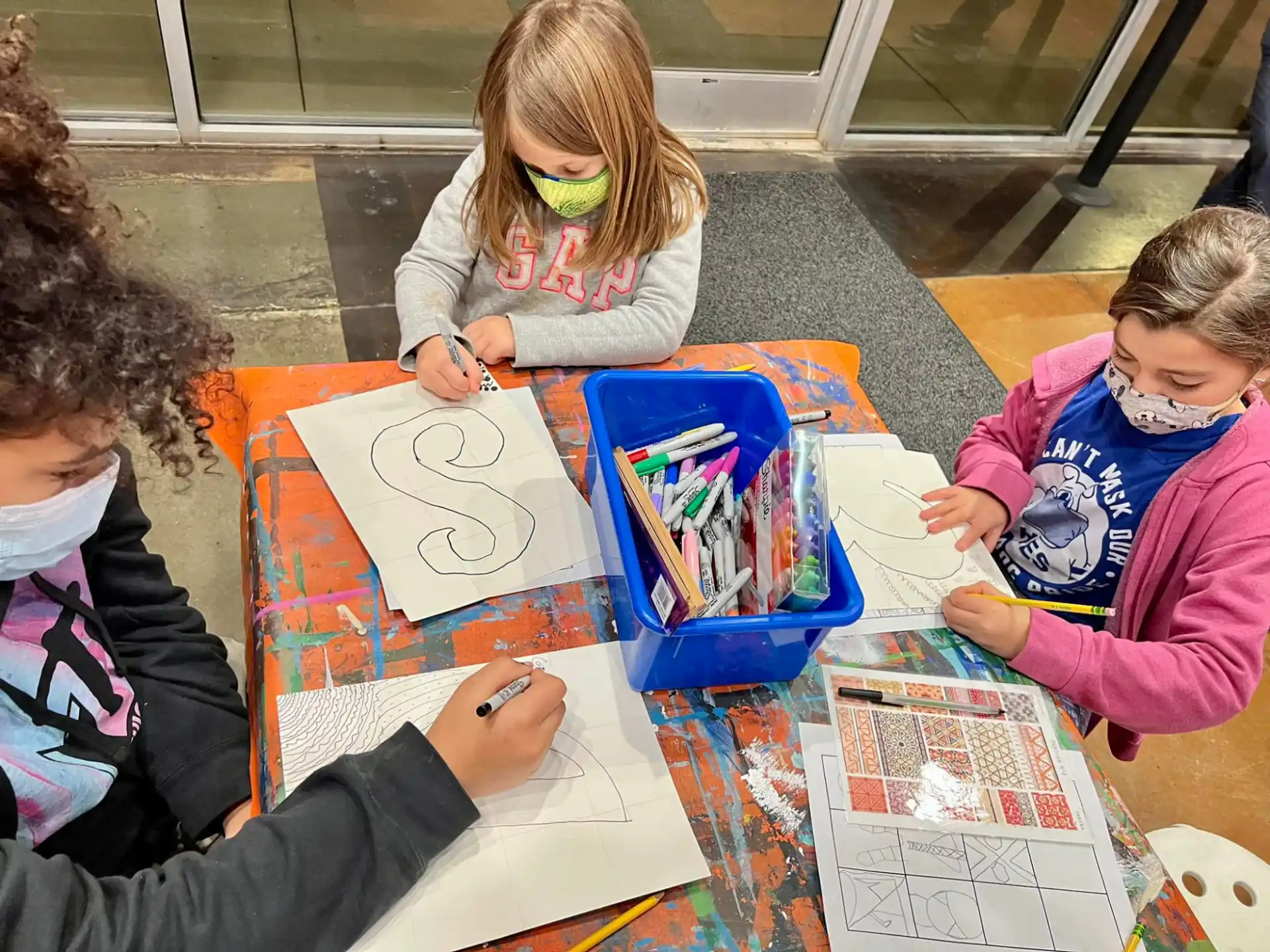 a group of children sitting at a table with a board game