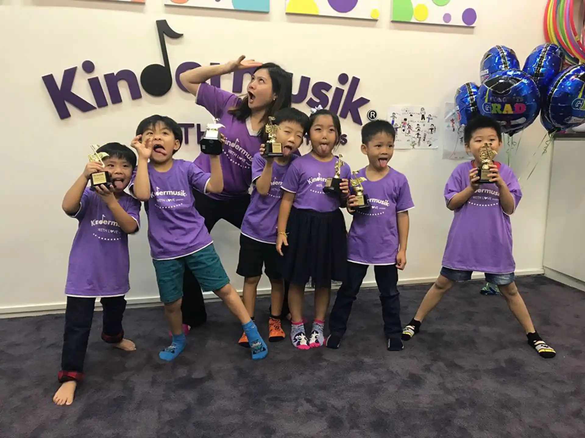 a group of kids posing for a picture with balloons