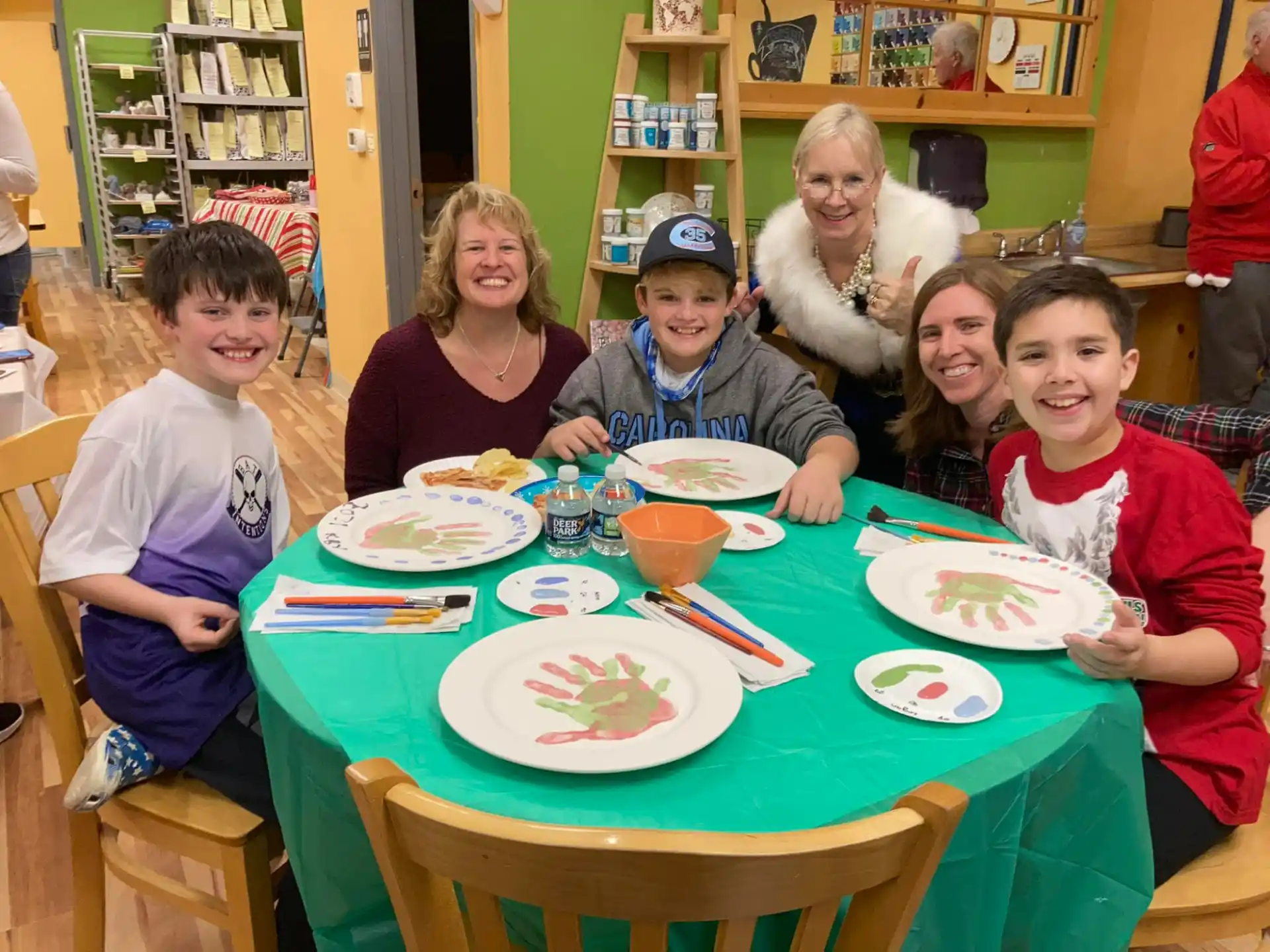 a group of people sitting around a table with plates of food