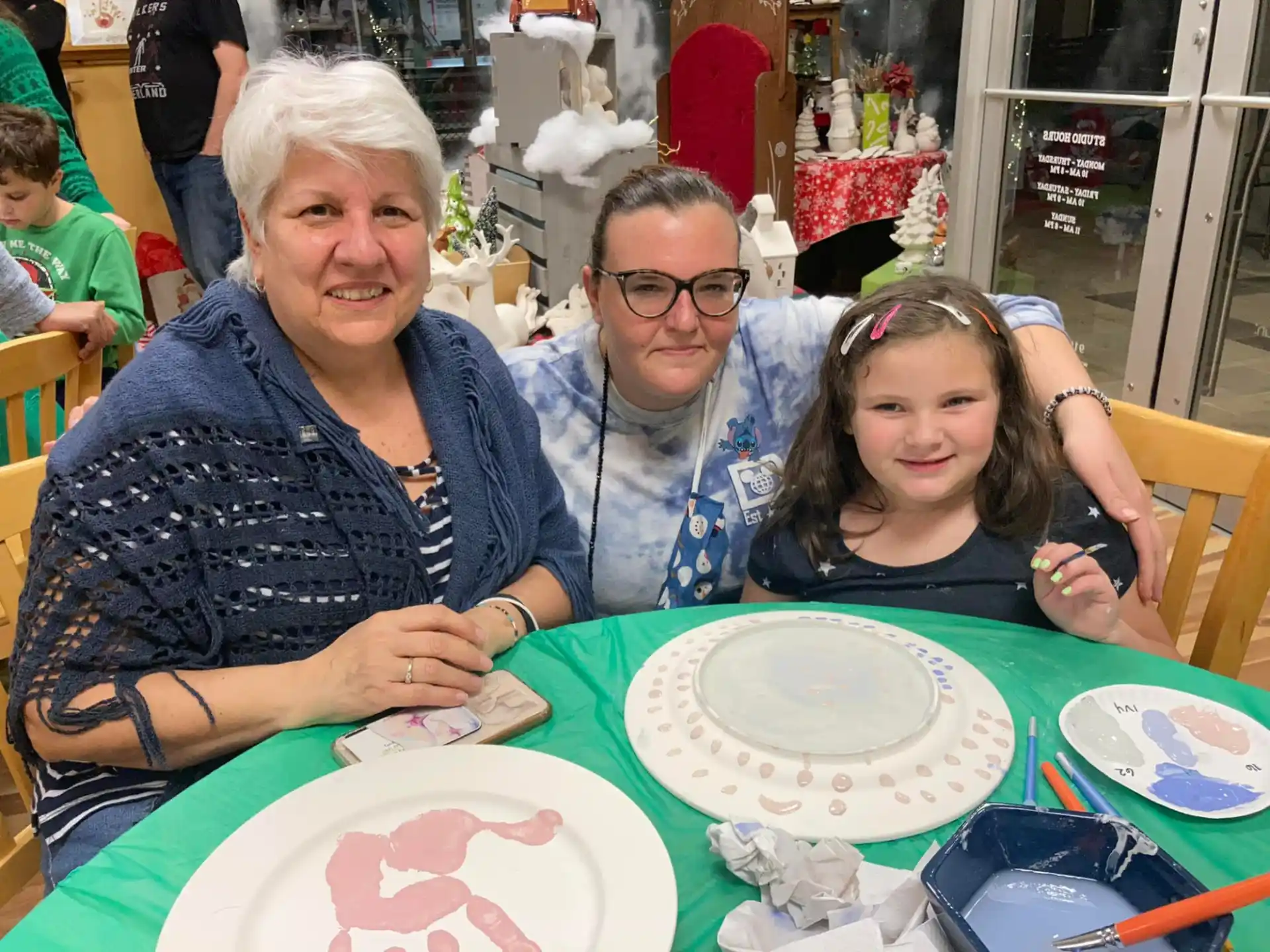 a group of people sitting at a table with plates and cups