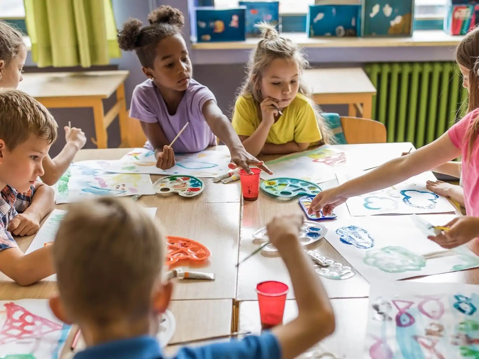 a group of children sitting around a table