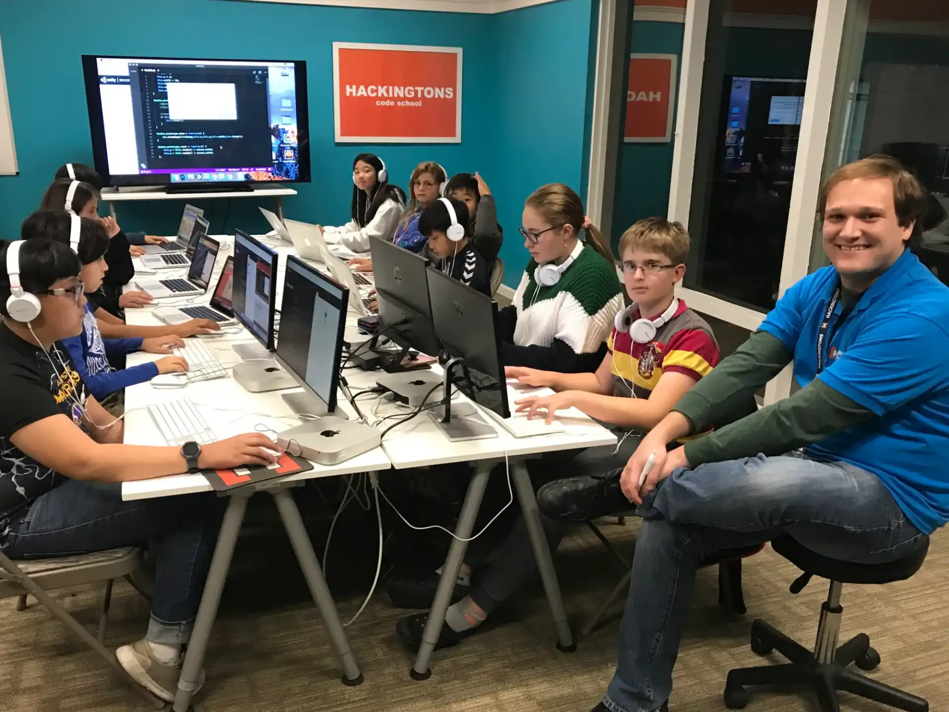 a group of people sitting at a table with computers