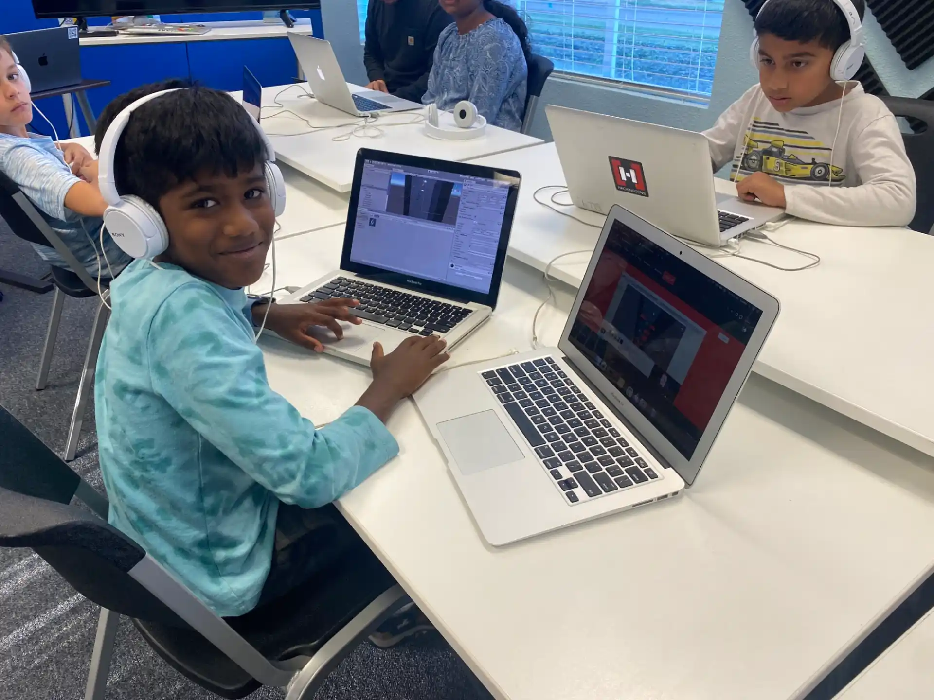 a few young boys using laptops