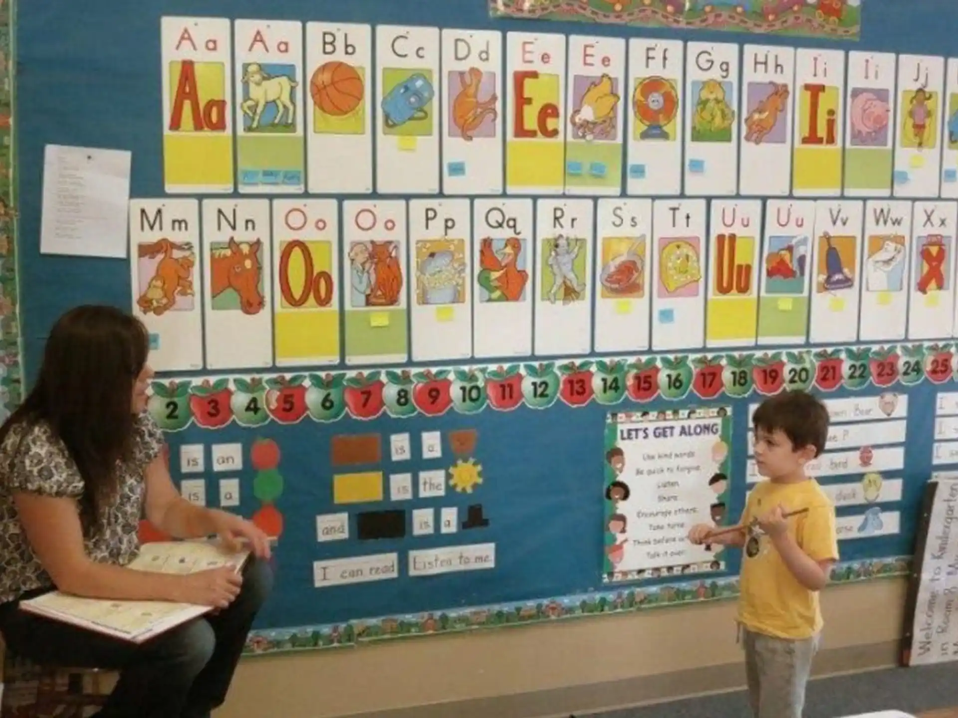 a person and a child in front of a wall with posters