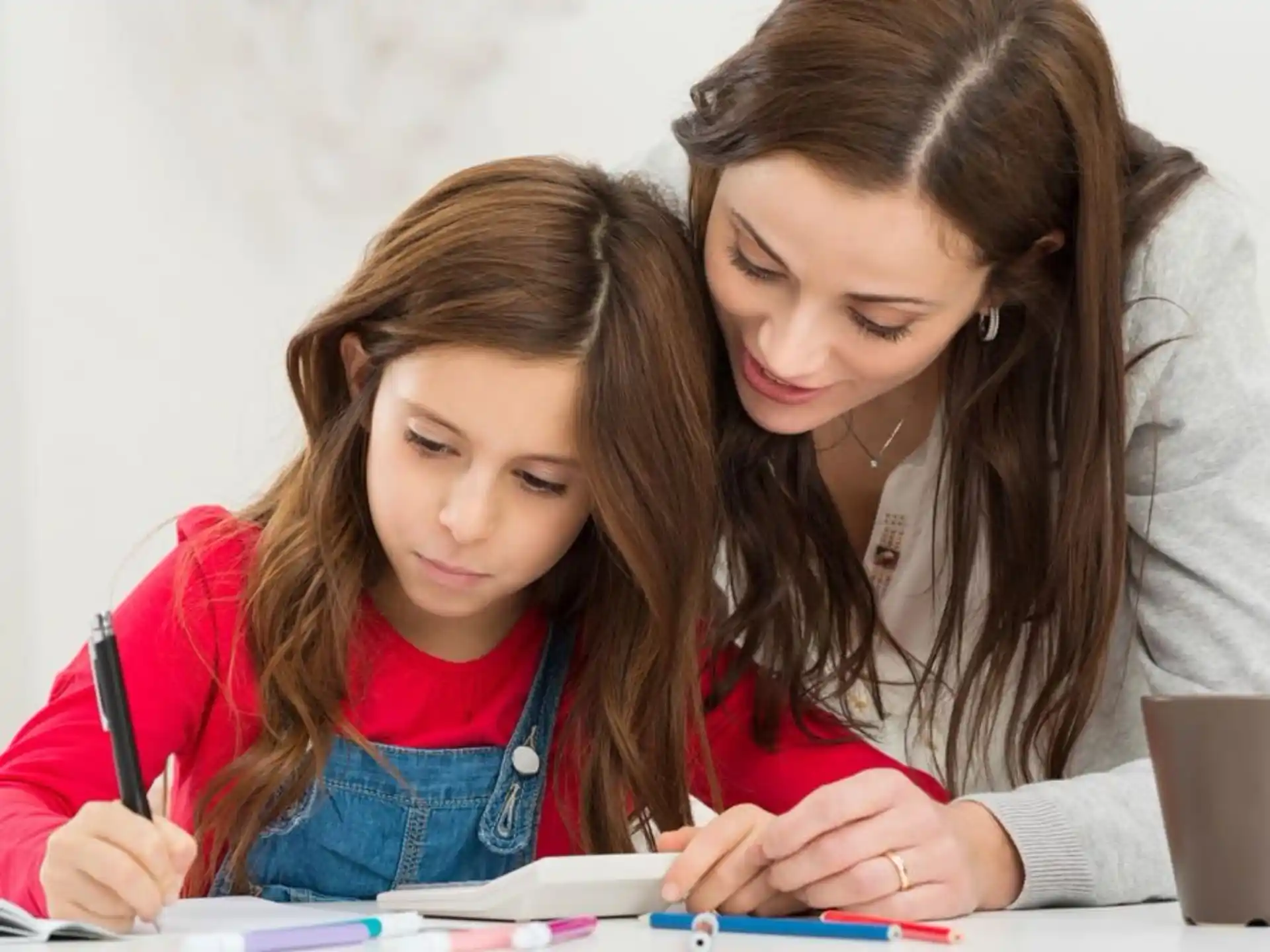 a woman and a girl looking at a book