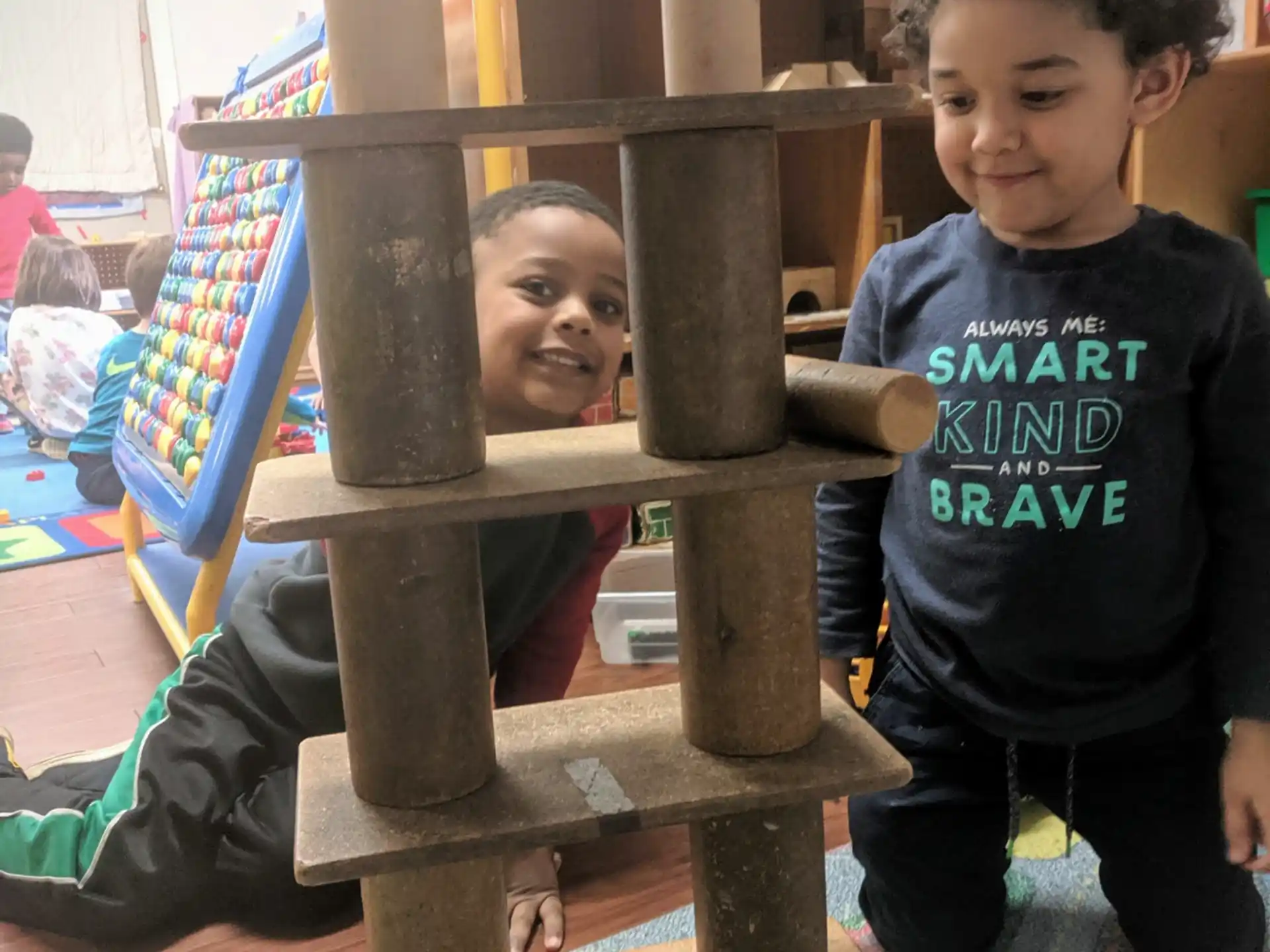 a couple of boys playing on a wooden structure