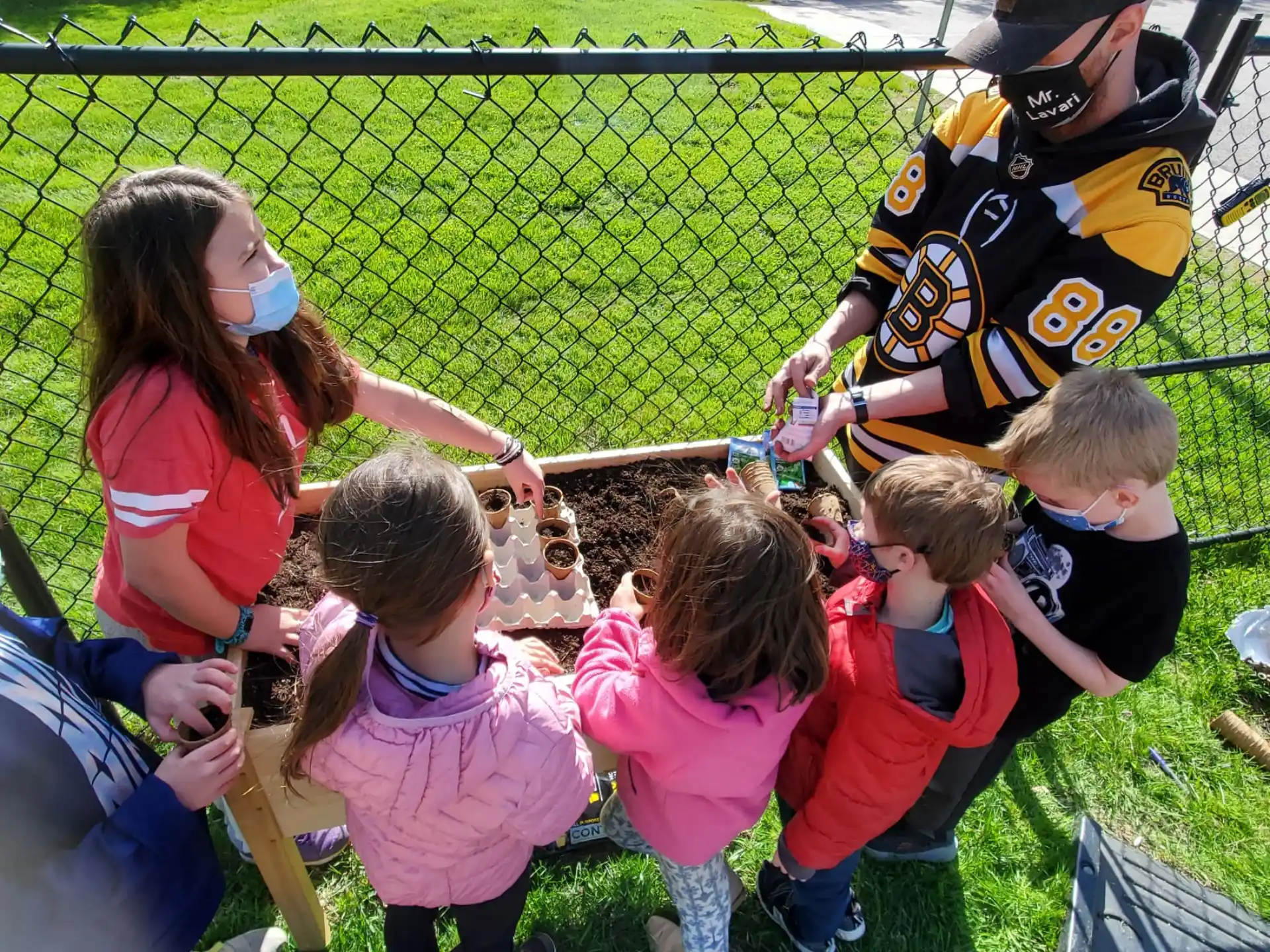 a group of children playing with a person in a mask