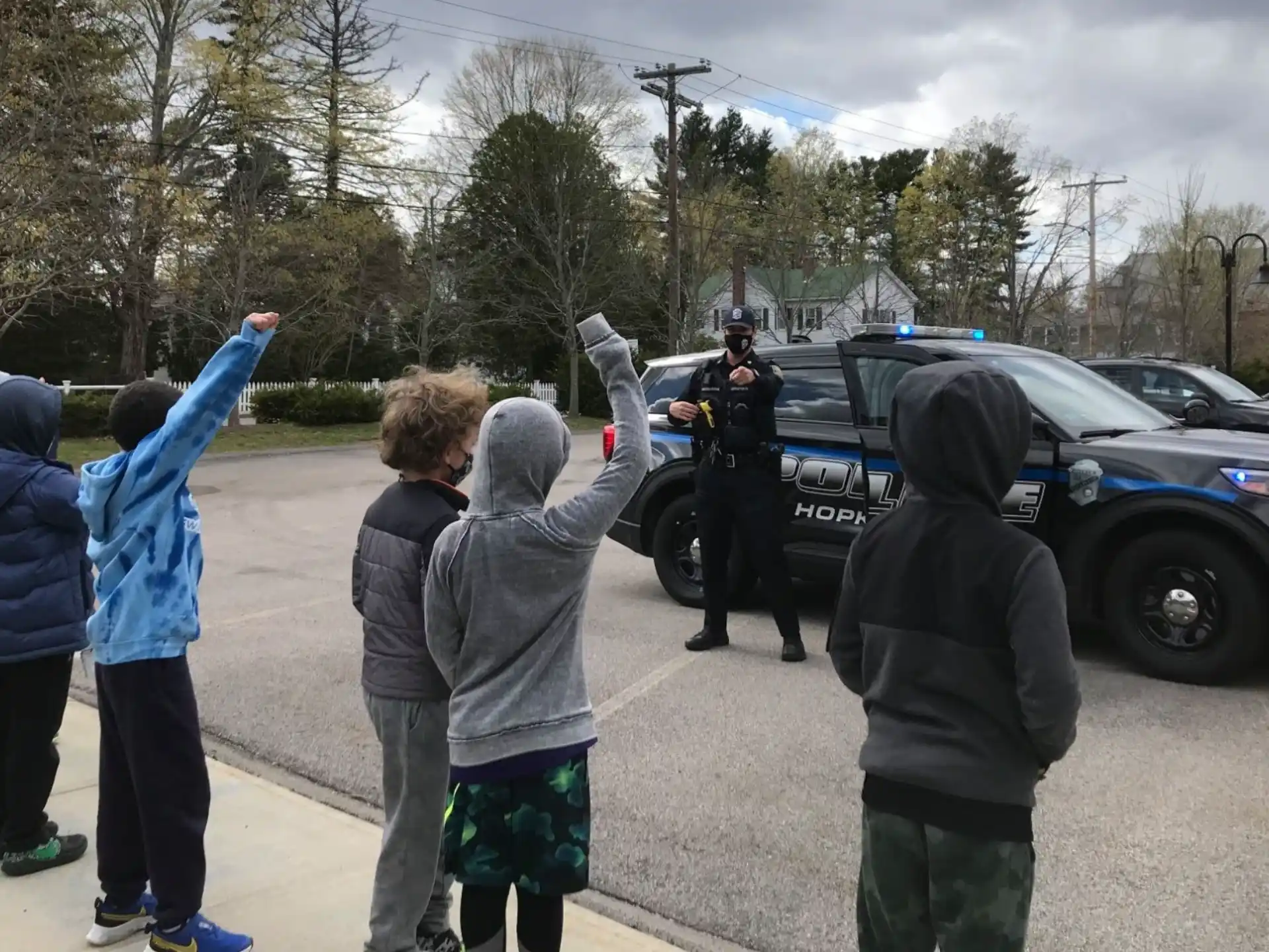 a group of people standing in a parking lot with a police officer