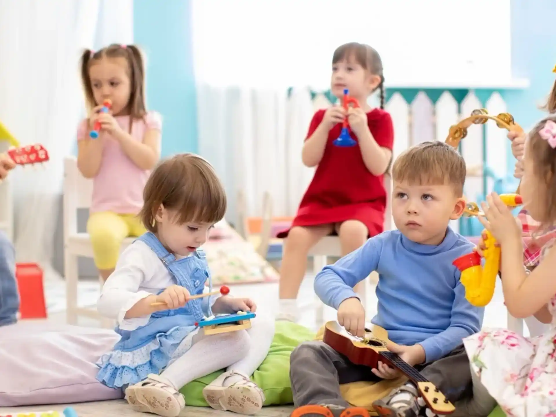 a group of children sitting on the floor with toothbrushes