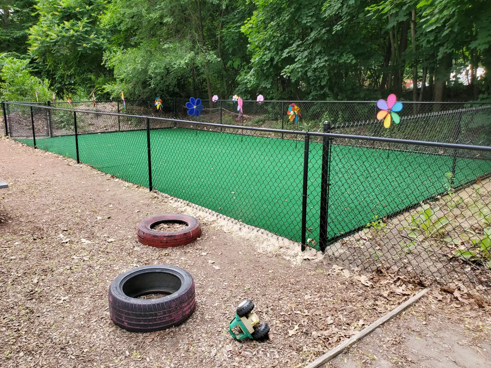 a fenced in area with a group of people in the background