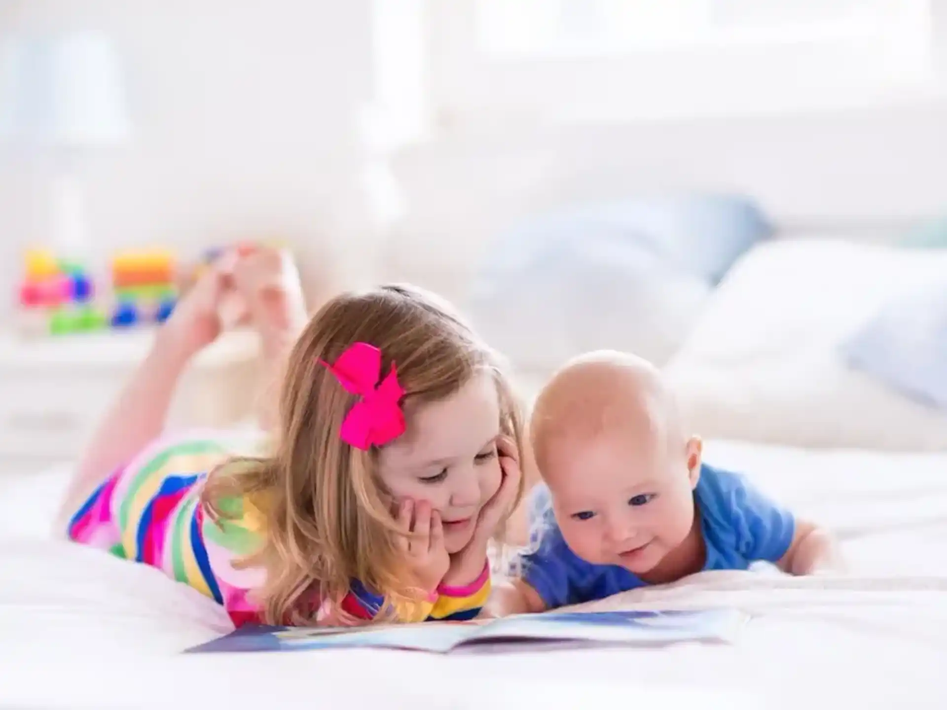 a baby and a baby lying on a bed