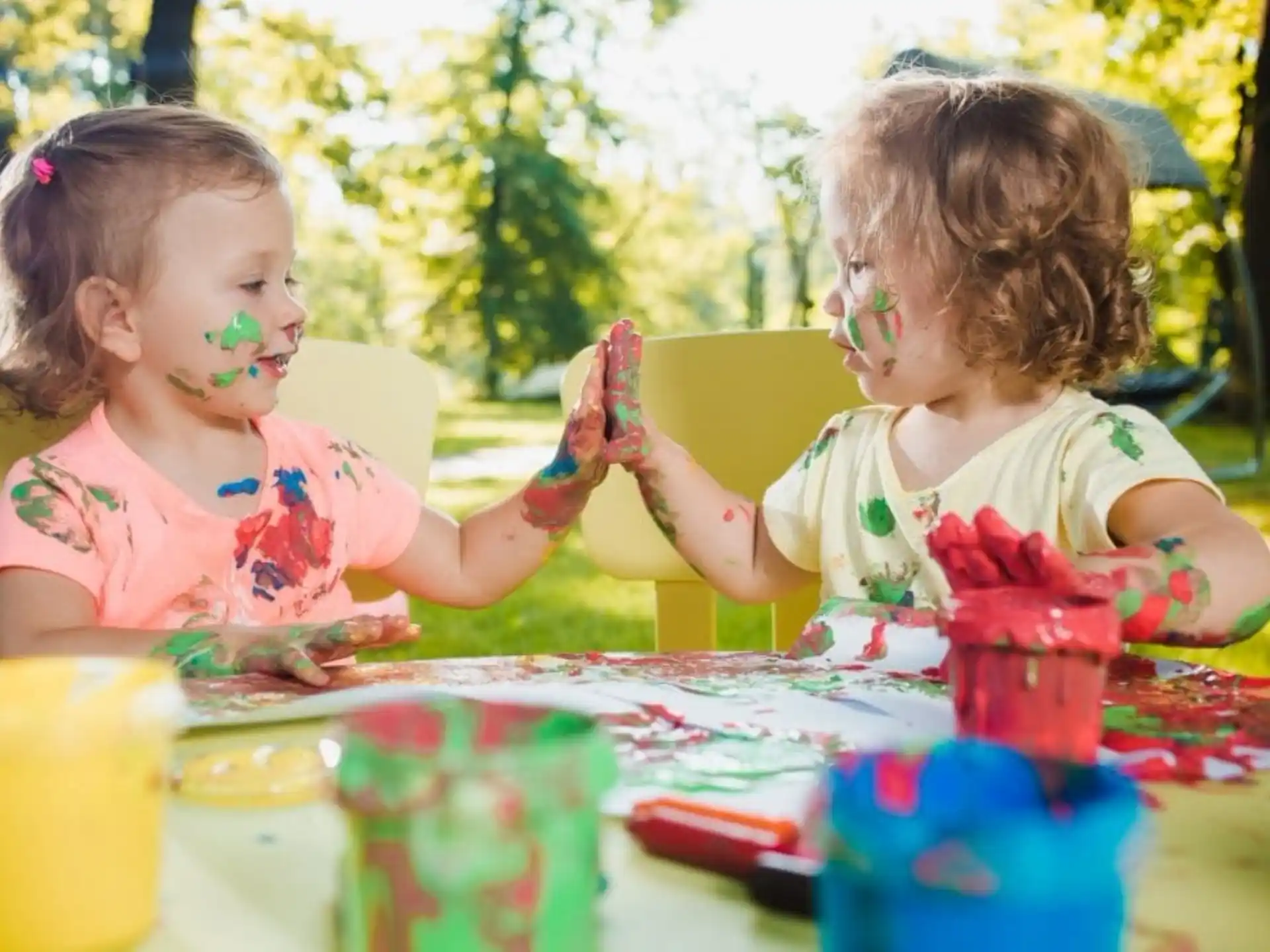 a couple of young girls playing with a cake