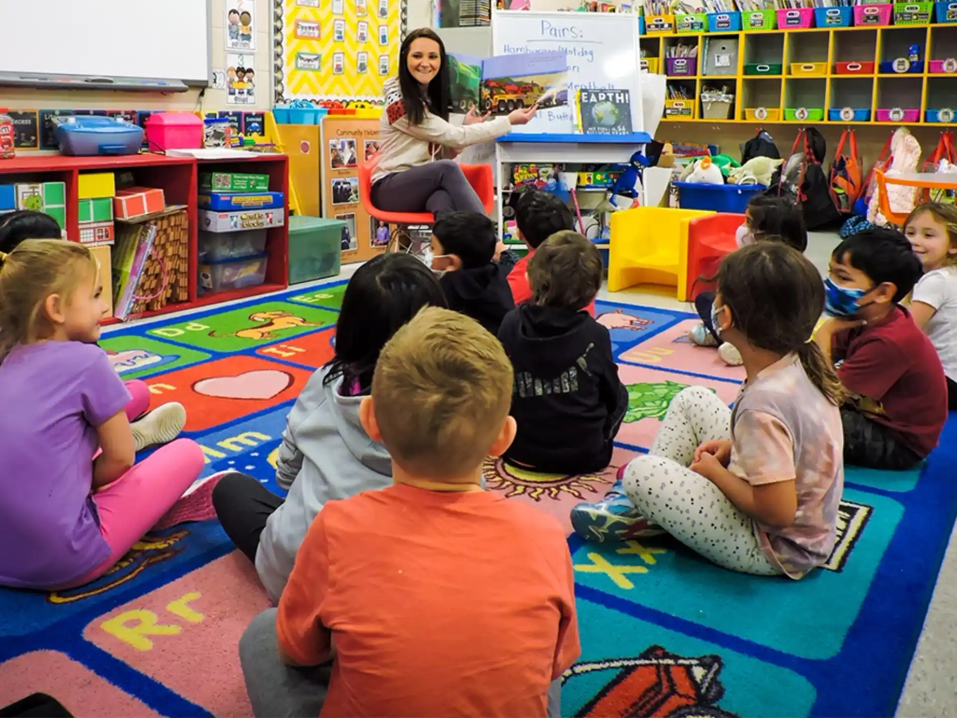 a group of children sitting on the floor in a classroom