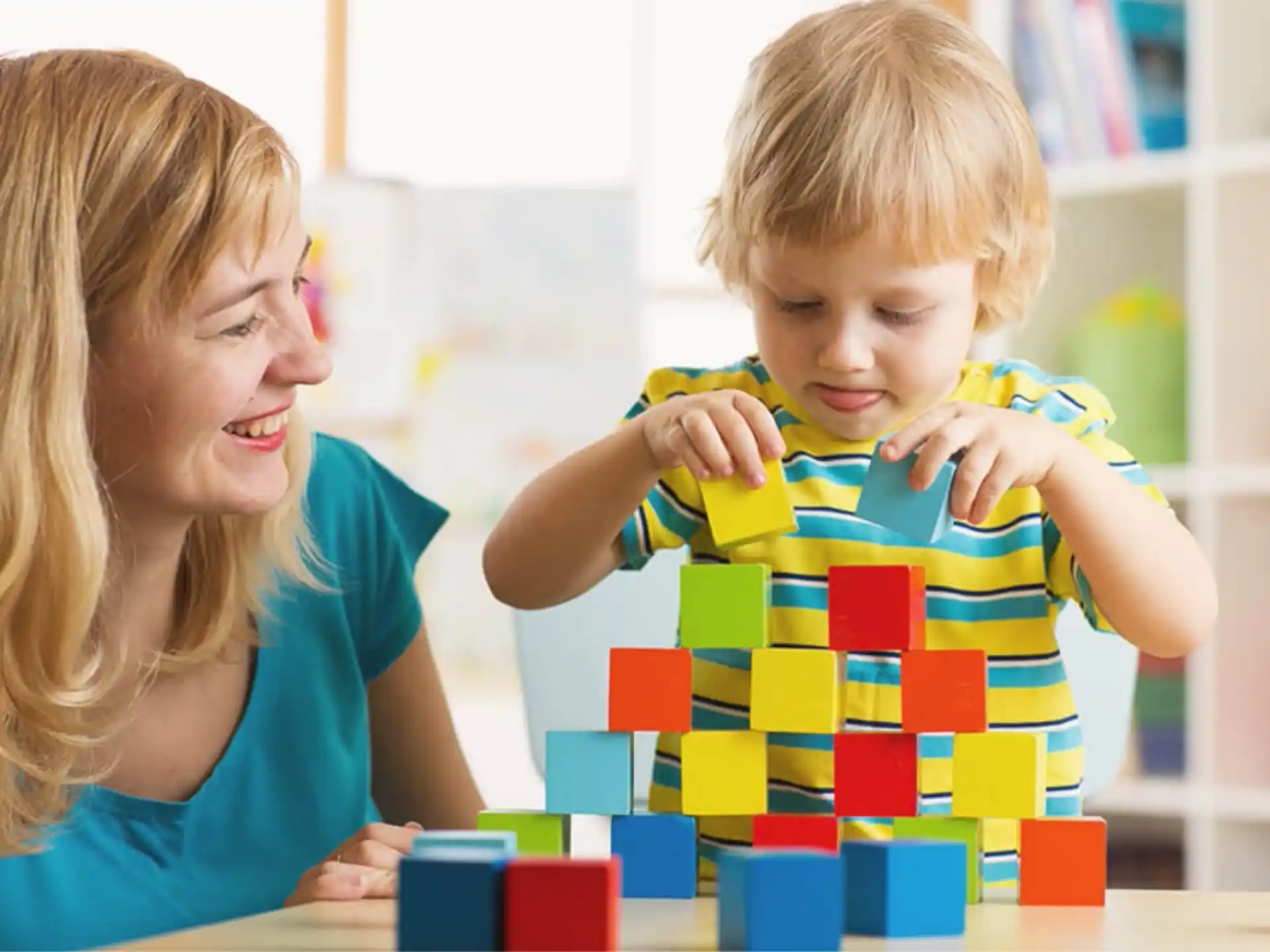 a person and a child playing with blocks