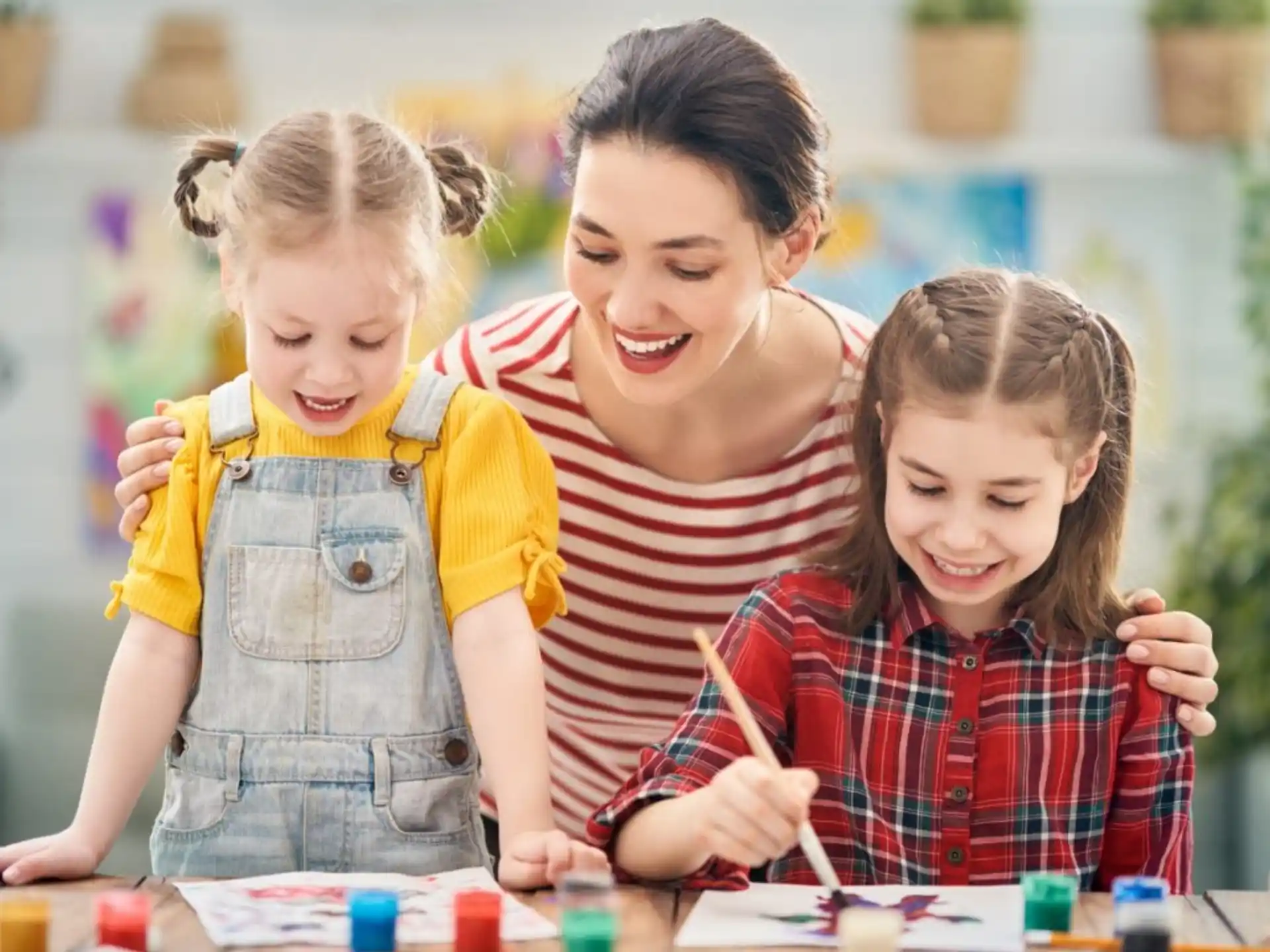 a person and two children painting