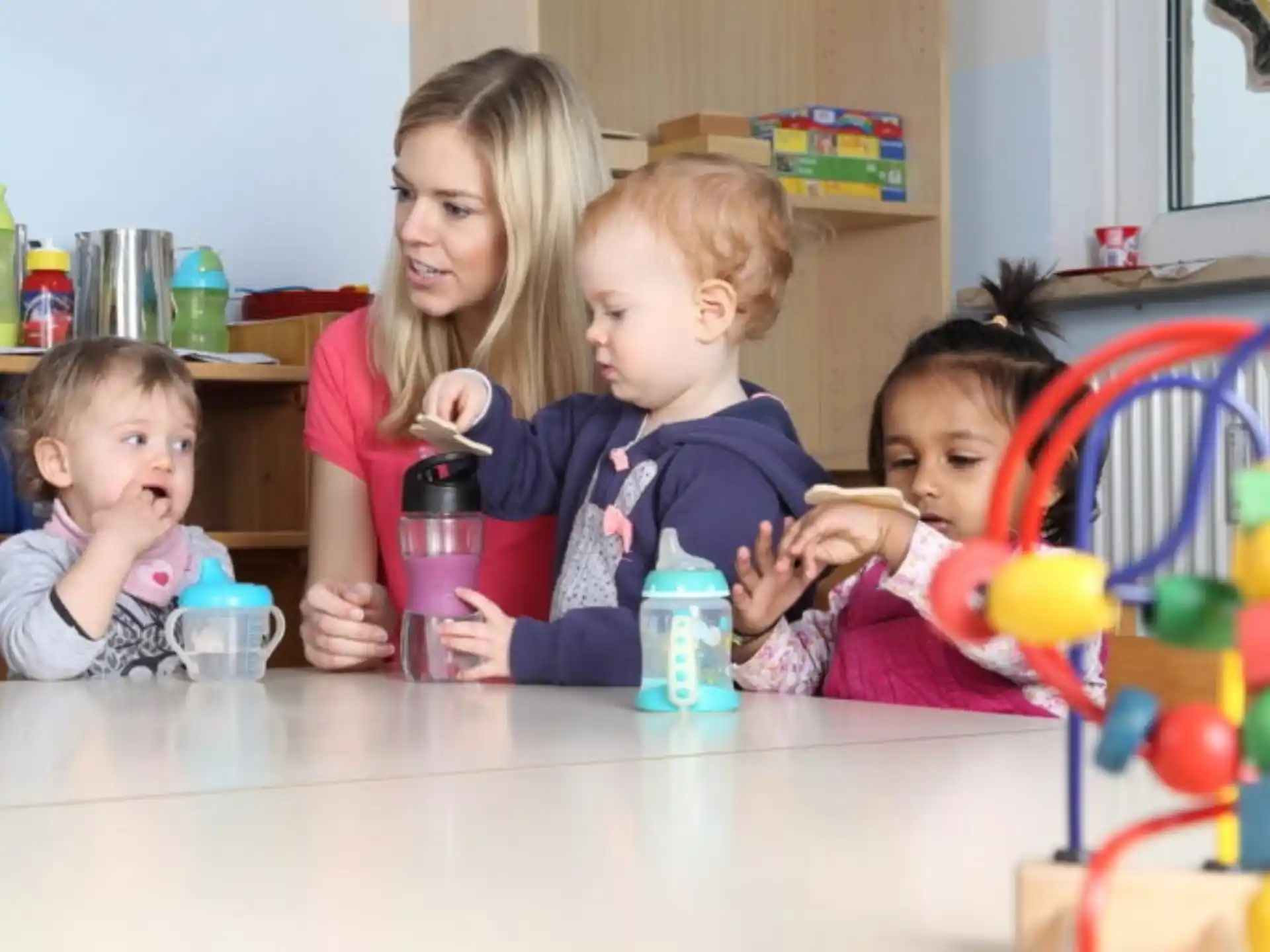 a person and two children sitting at a table with a toy